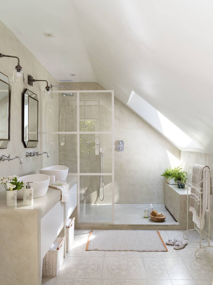 Baño con mampara de ducha con perfiles blancos, mueble de obra y dos espejos con aplique. 