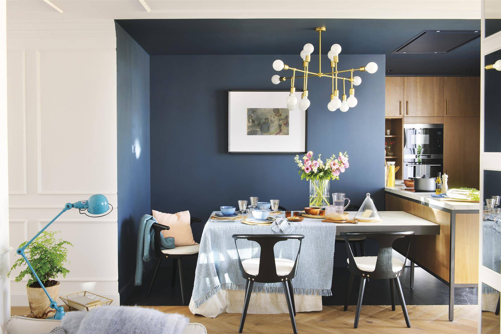 Comedor con paredes azules y sillas de color negro. 