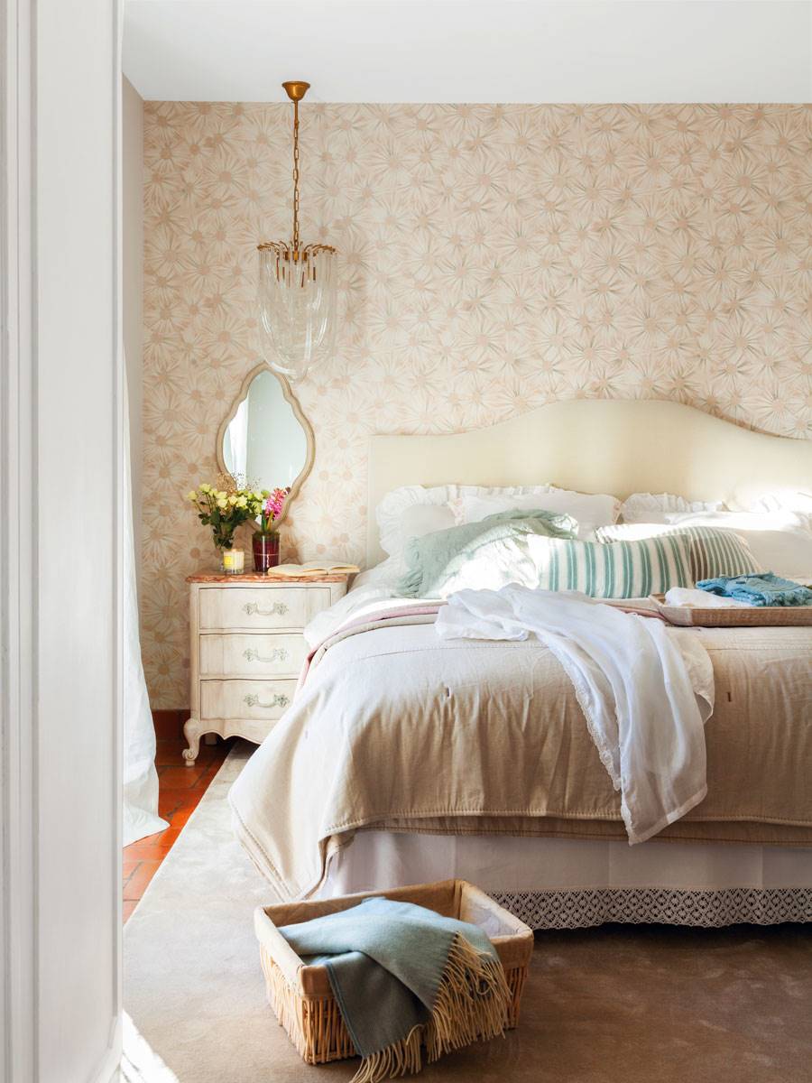 Dormitorio con papel pintado y cabecero tapizado. 