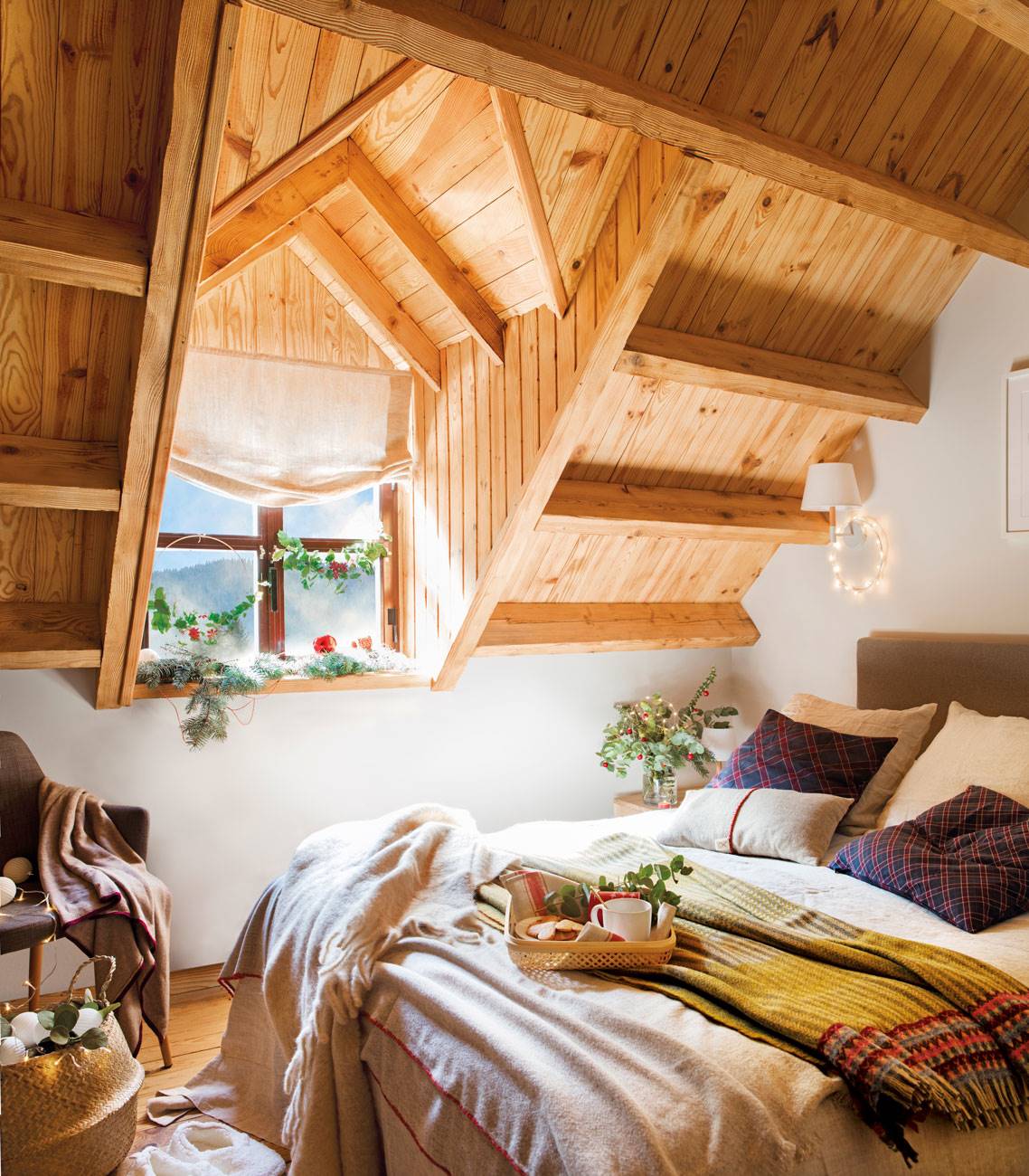 Dormitorio abuhardillado con techo de madera. 