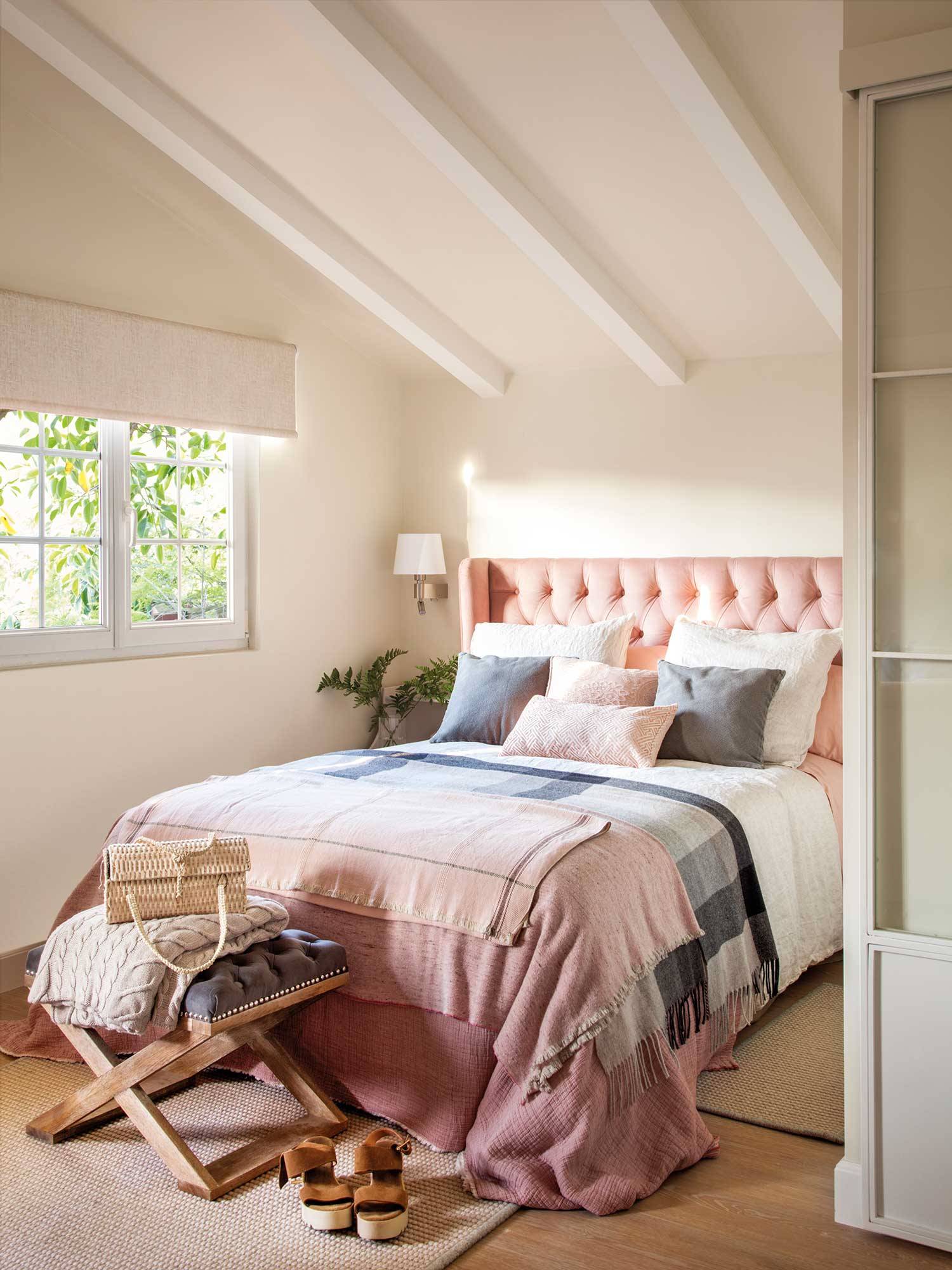 Dormitorio de primavera con cabecero de orejas en capitoné y ropa de cama en color rosa pastel.