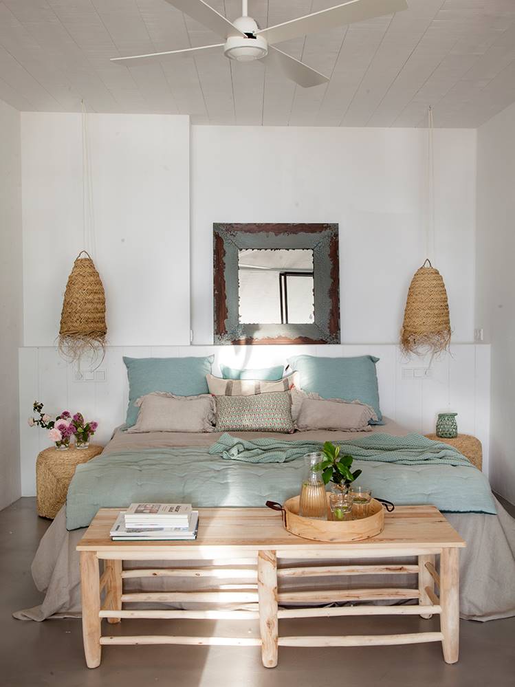 Dormitorio de primavera con fibras naturales en mesitas y lámparas suspendidas.