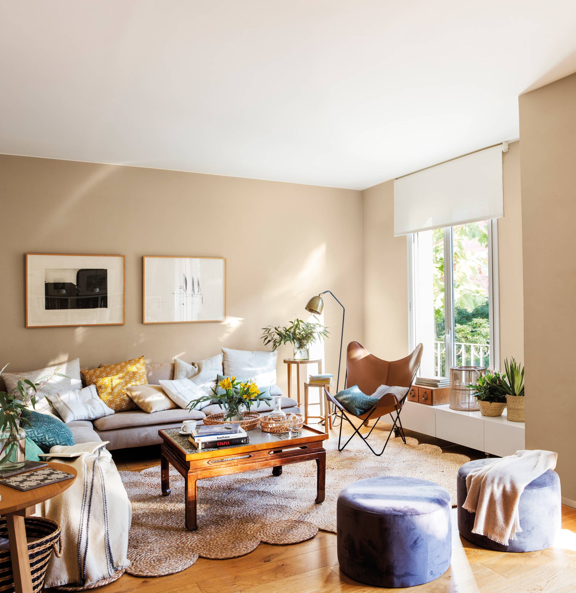 Salón con paredes pintadas de beige, sofá gris y butaca Buterfly.