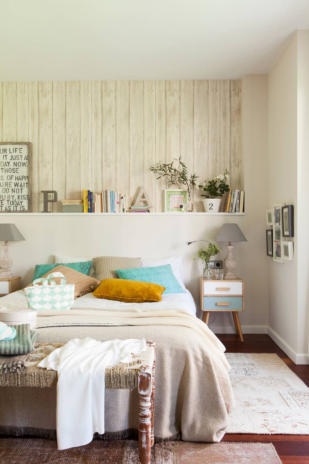 Dormitorio con cabecero de obra y papel pintado que imita la madera. 