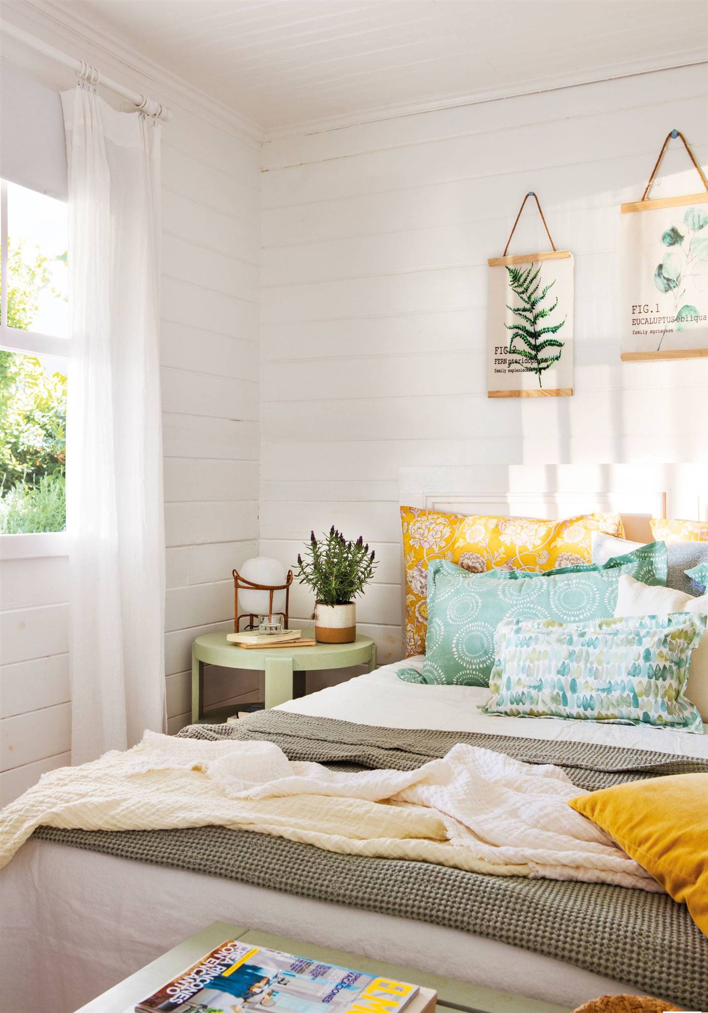 Dormitorio rústico con lamas de madera blanca en las paredes y ropa de cama en tonos verdes y amarillos