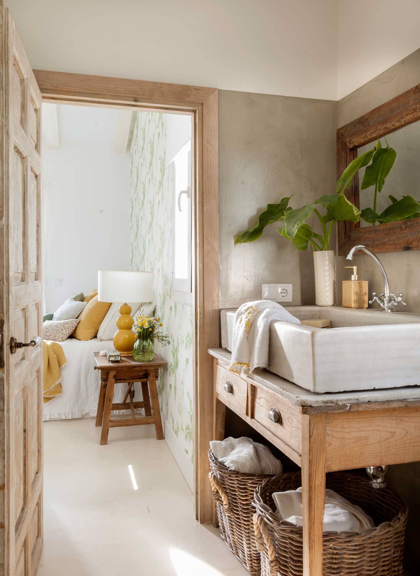 Baño con mueble bajolavabo y lavamanos de una tienda de antigüedades, y paredes de microcemento. 