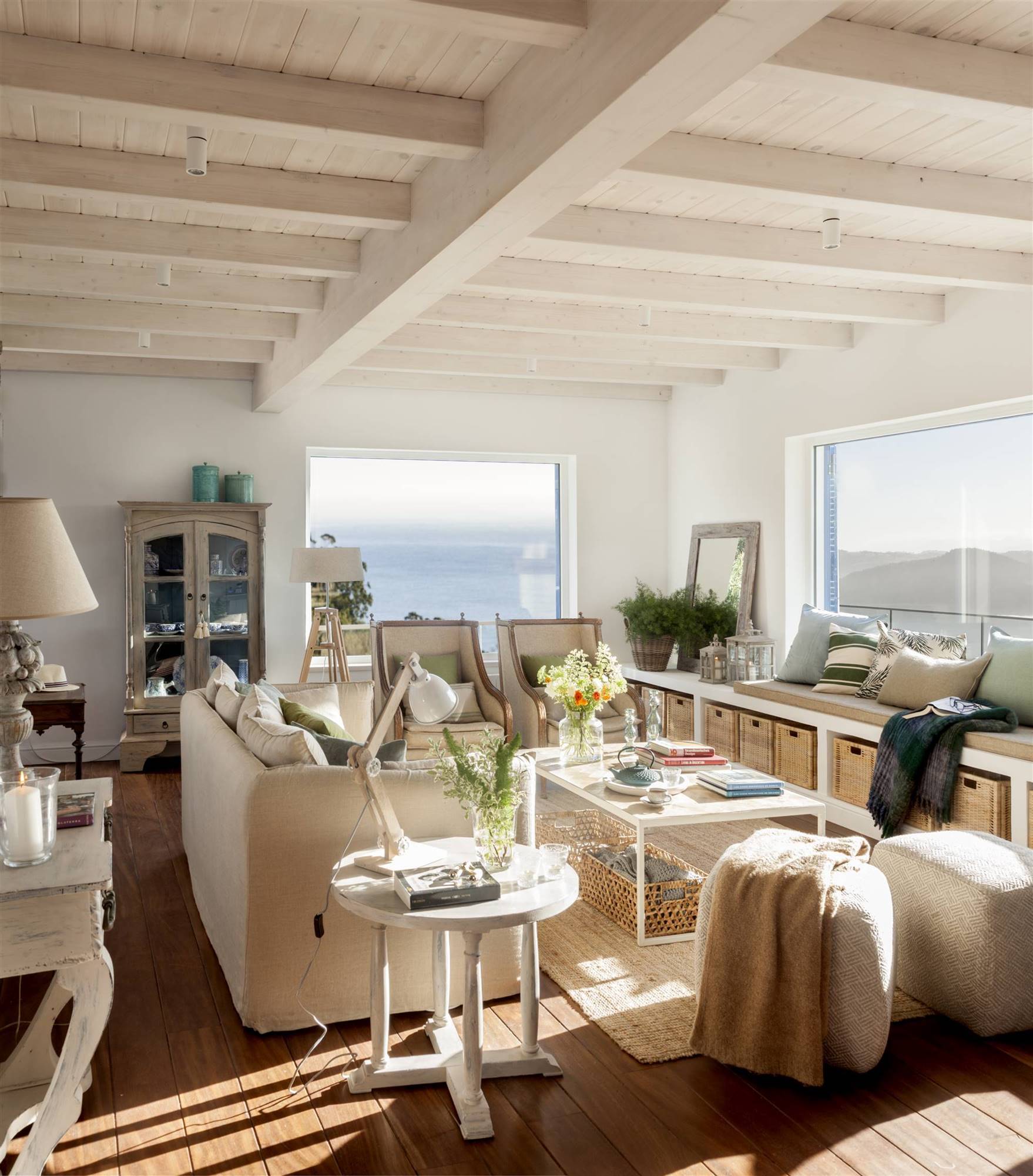 Salón con vistas al mar, banco en la ventana y muebles blancos 499100