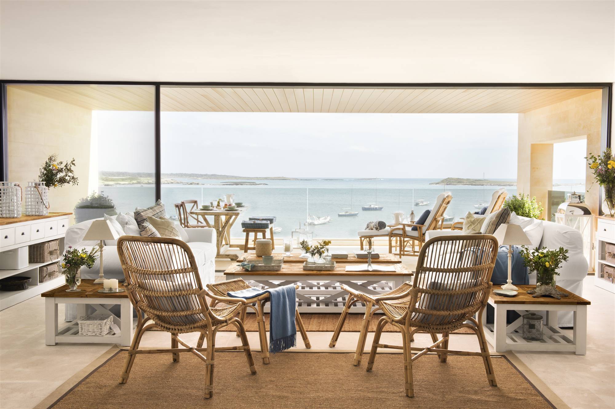 Salón con vistas al mar, sillones de fibras y sofás blancos 454170