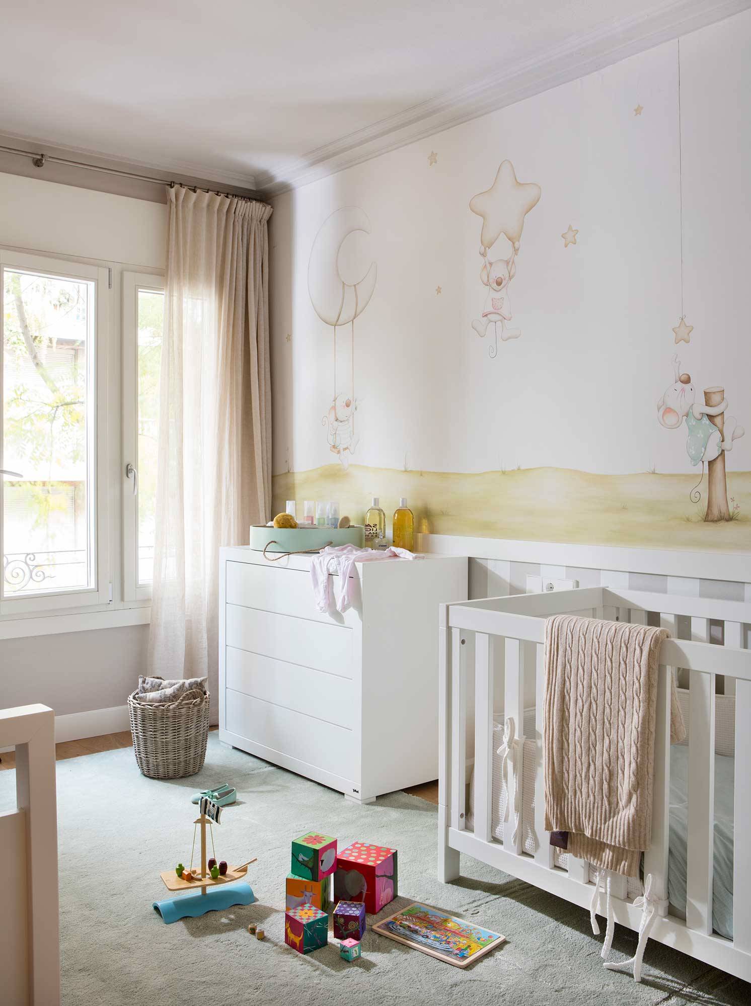 Dormitorio del bebé con un mural decorativo en la pared. 