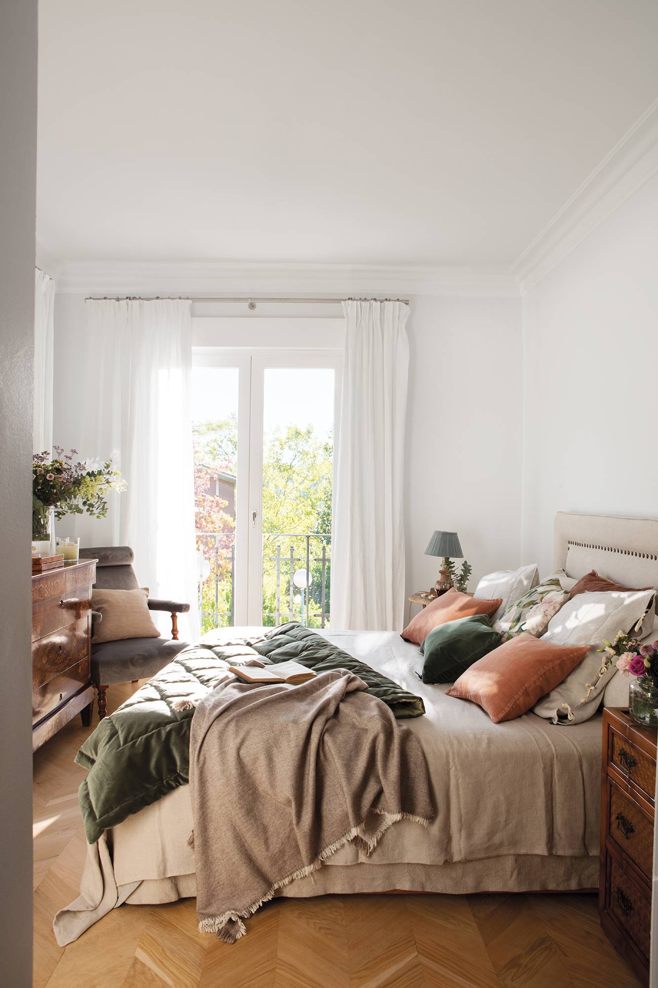 Dormitorio con cojines en terciopelo y visillos blancos