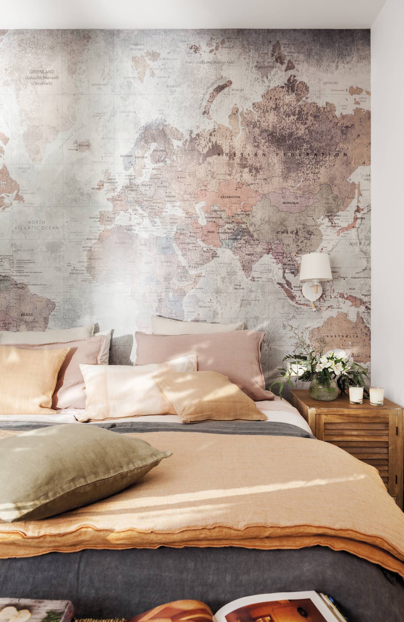Dormitorio con mapa en pared cojines naranja y coral. 