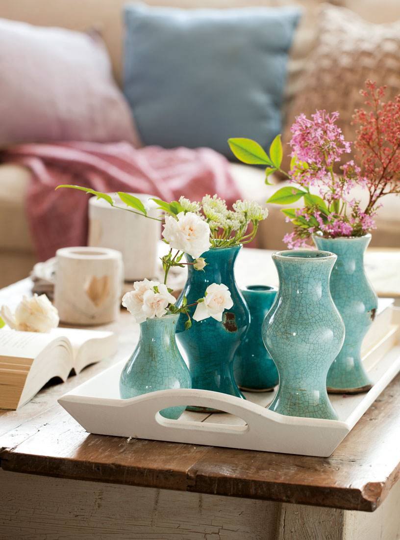 Detalle de jarrones con flores en color turquesa.