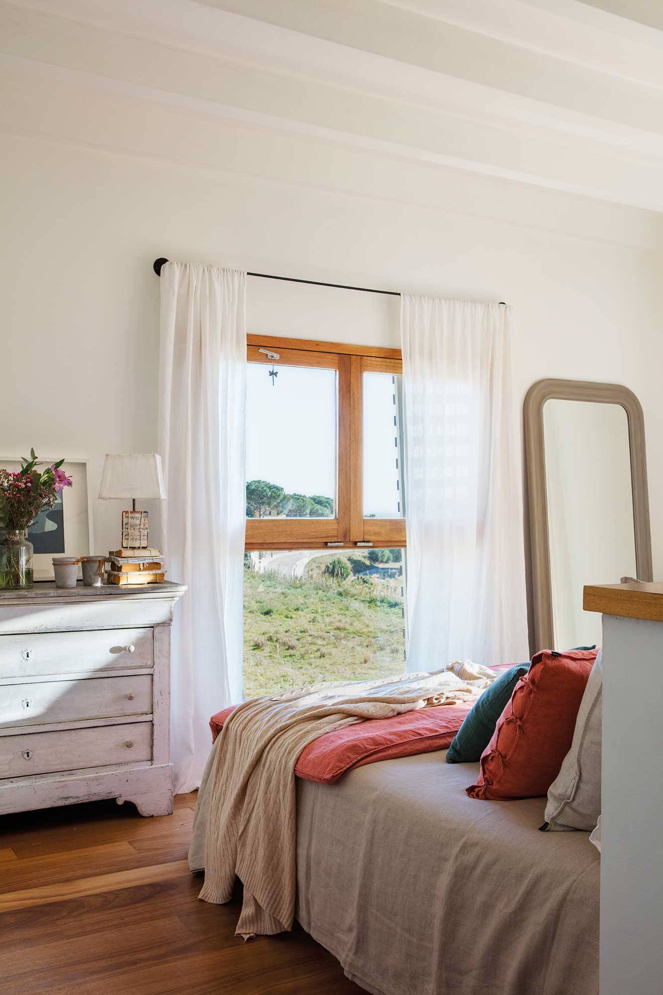 Dormitorio con cortinas blancas y ligeras.