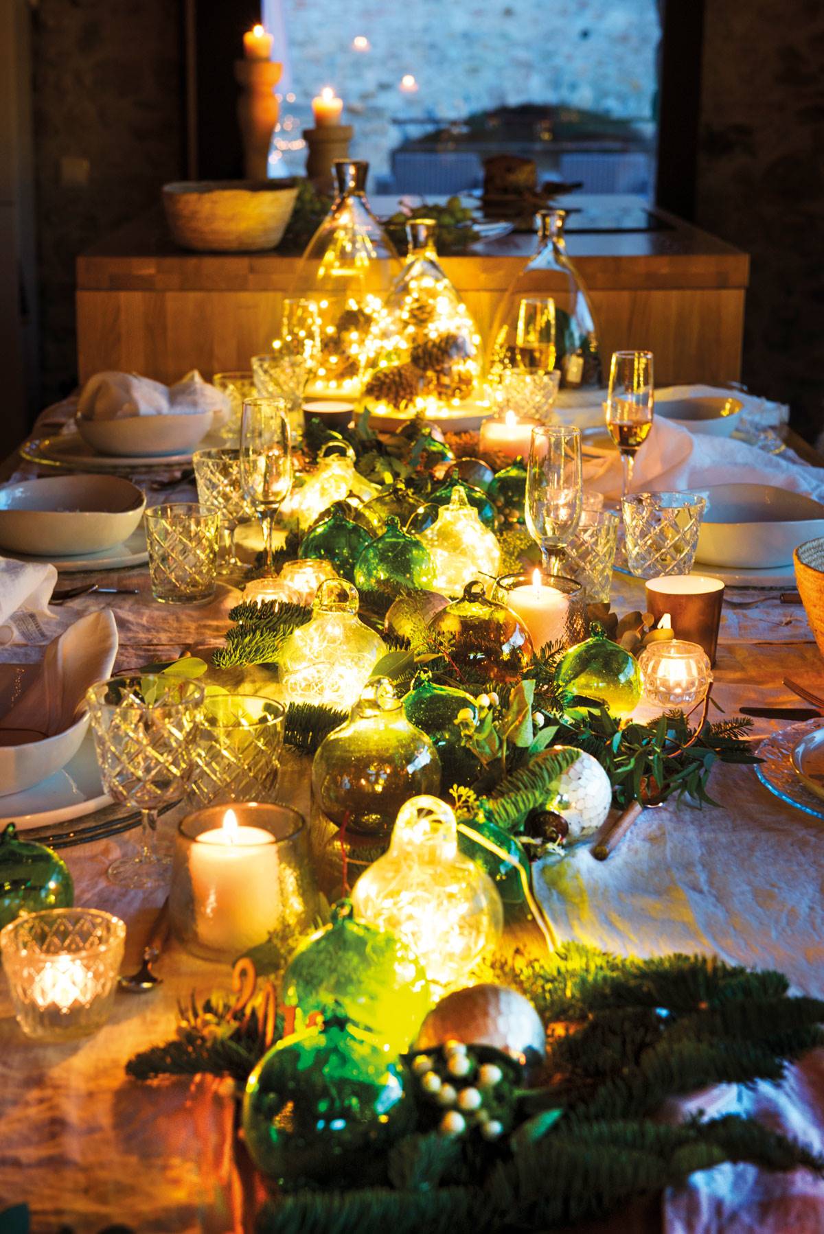 Centro de mesa navideño decorado con velas y guirnaldas luminosas.
