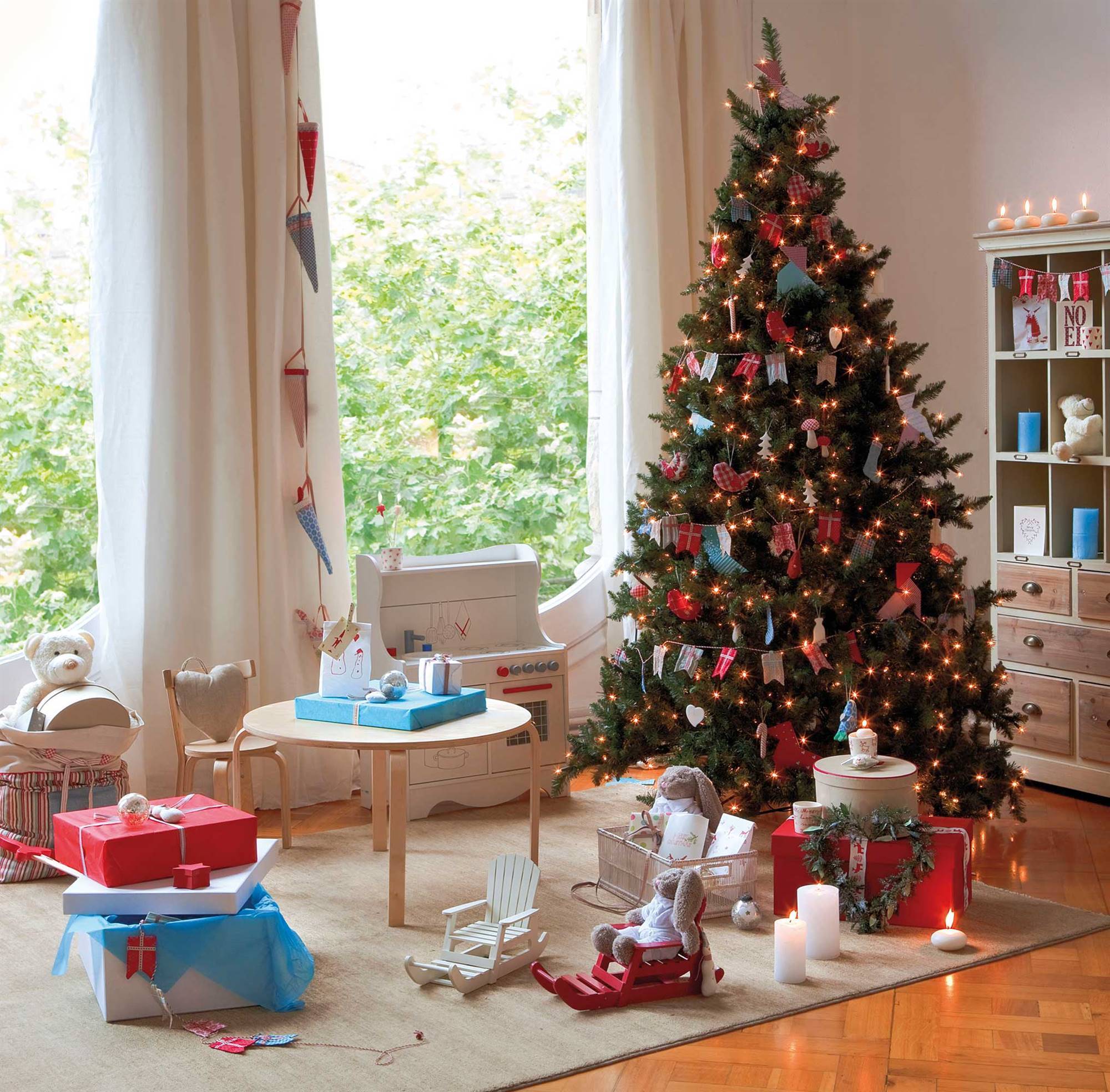 Zona de juegos infantil con árbol de Navidad decorado con banderas.
