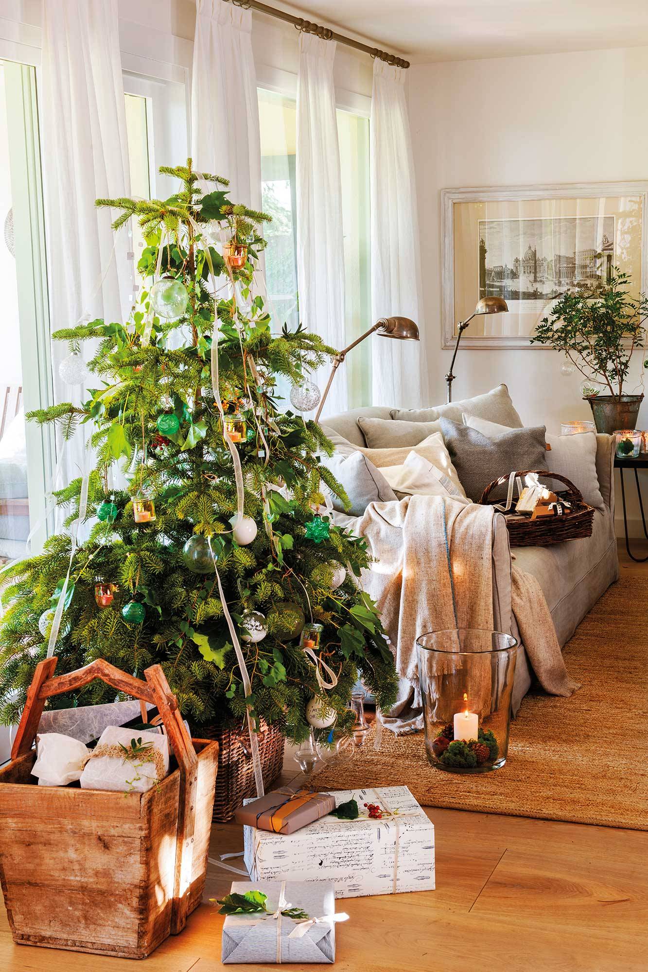 Salón con árbol de Navidad pequeño con ramitas de hiedra y alfombra de fibras.