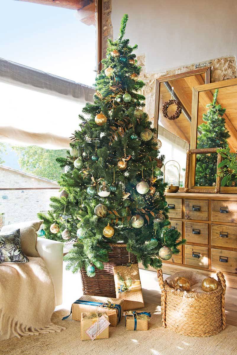 Salón con árbol de Navidad natural decorado en verde y dorado con toques de azul. 