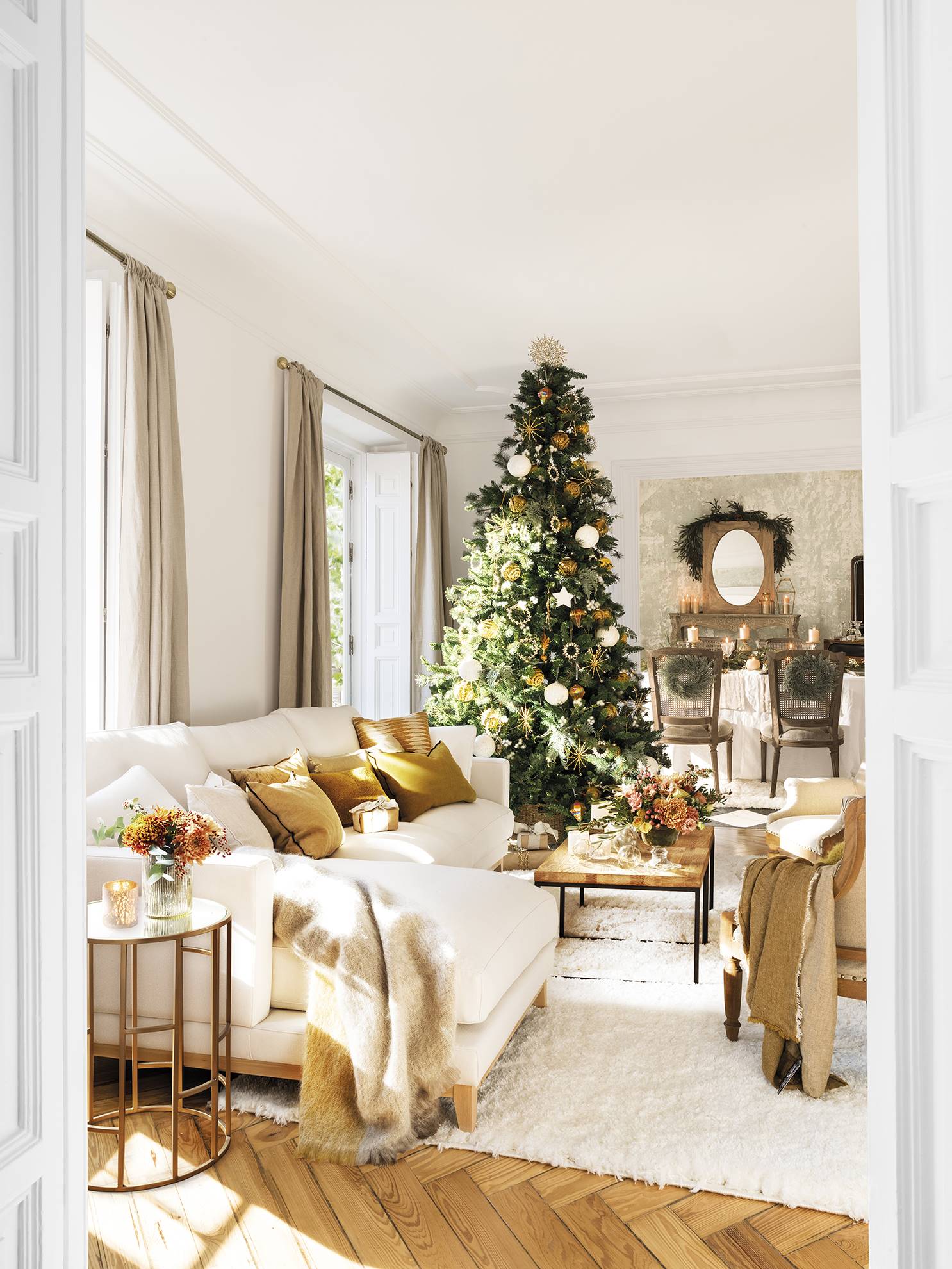 Un salón en tonos blancos y dorados muy navideño.