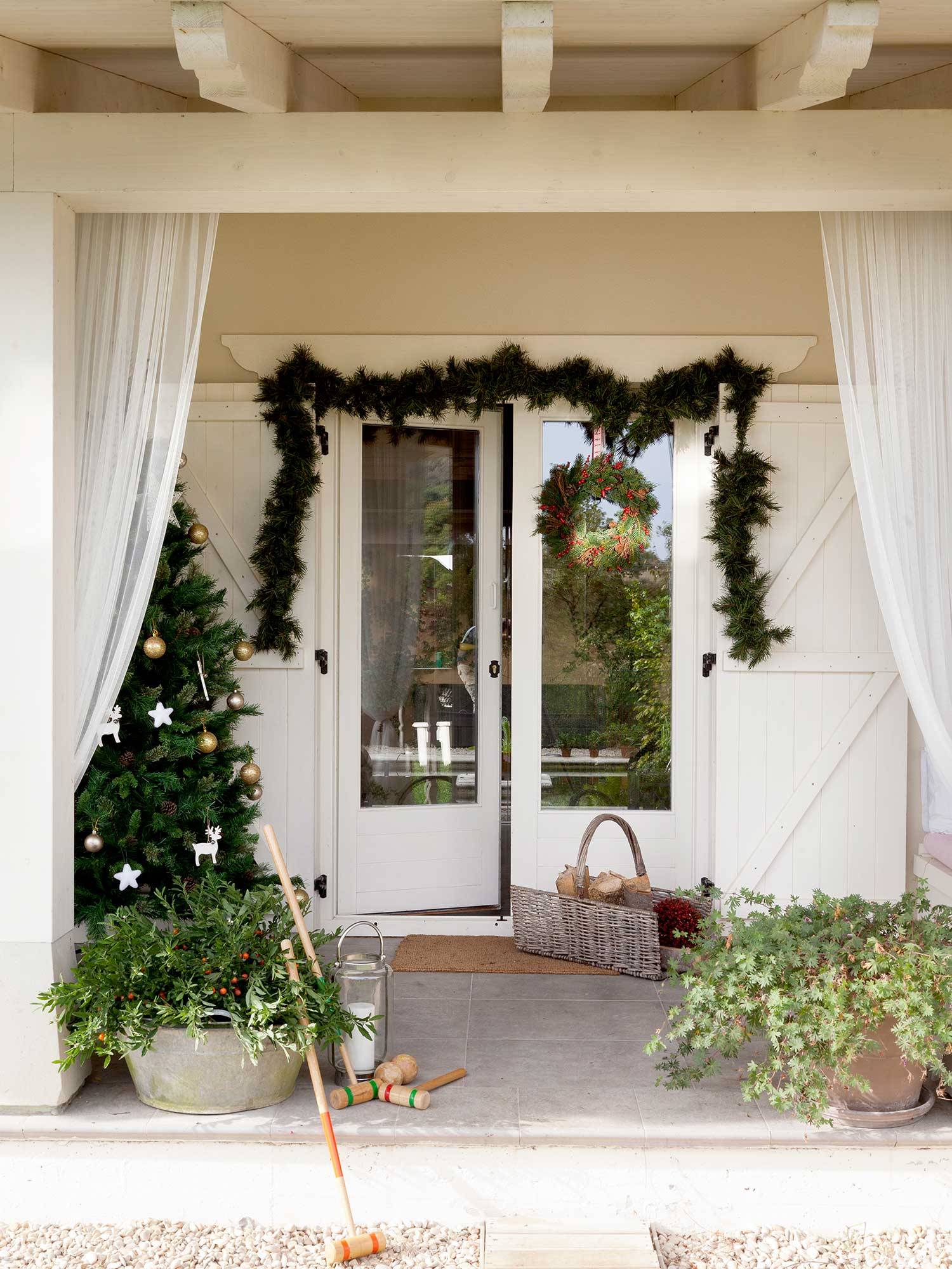 Una entrada decorada con todo detalle por Navidad con plantas