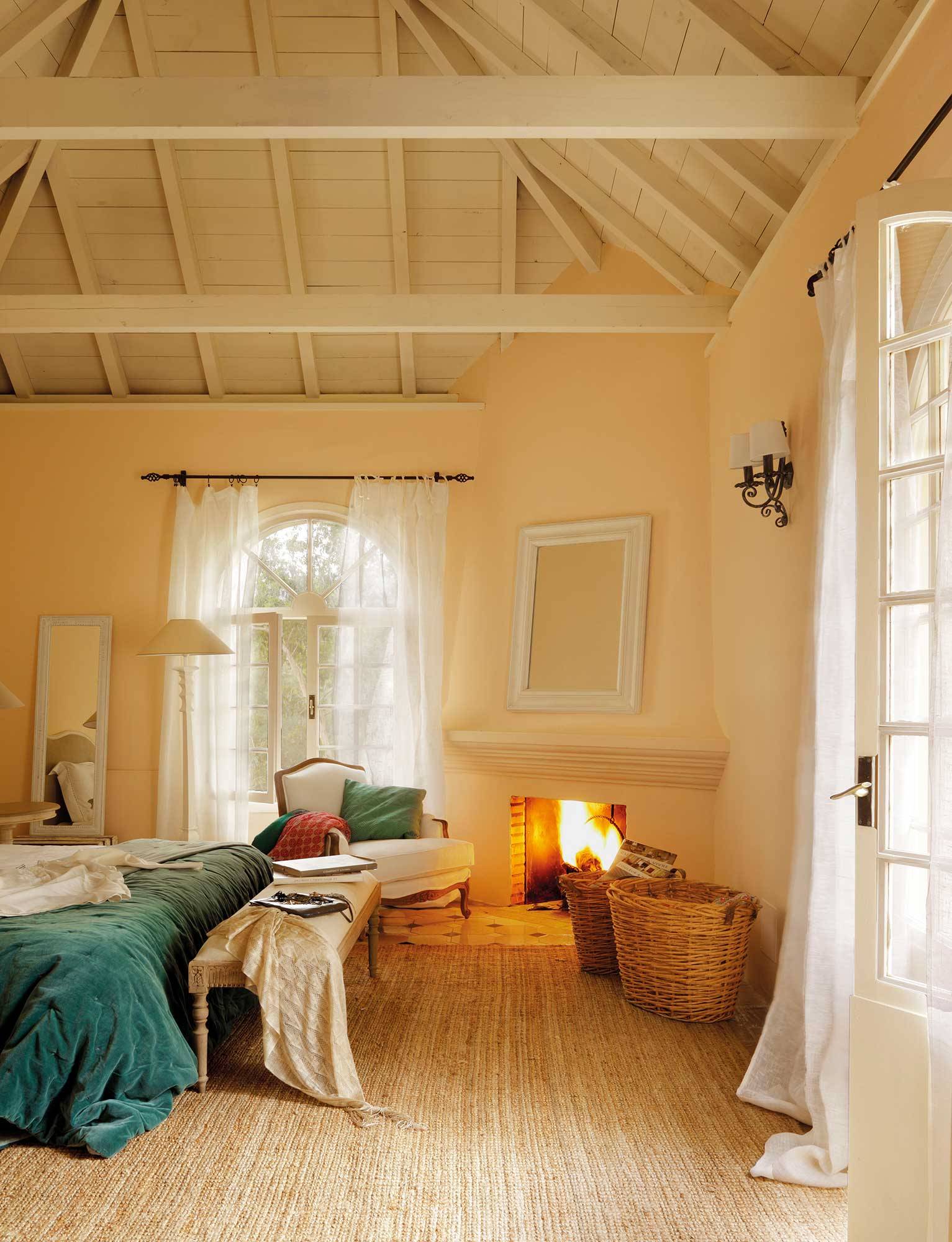 Dormitorio invernal con alfombra de fibras y chimenea encendida.