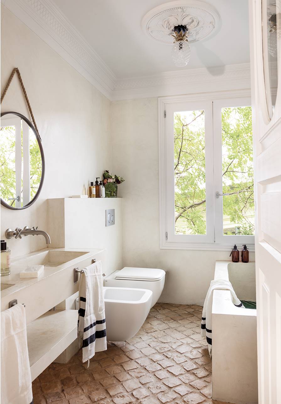 Baño con adoquines antiguos y microcemento en muebles y paredes. 