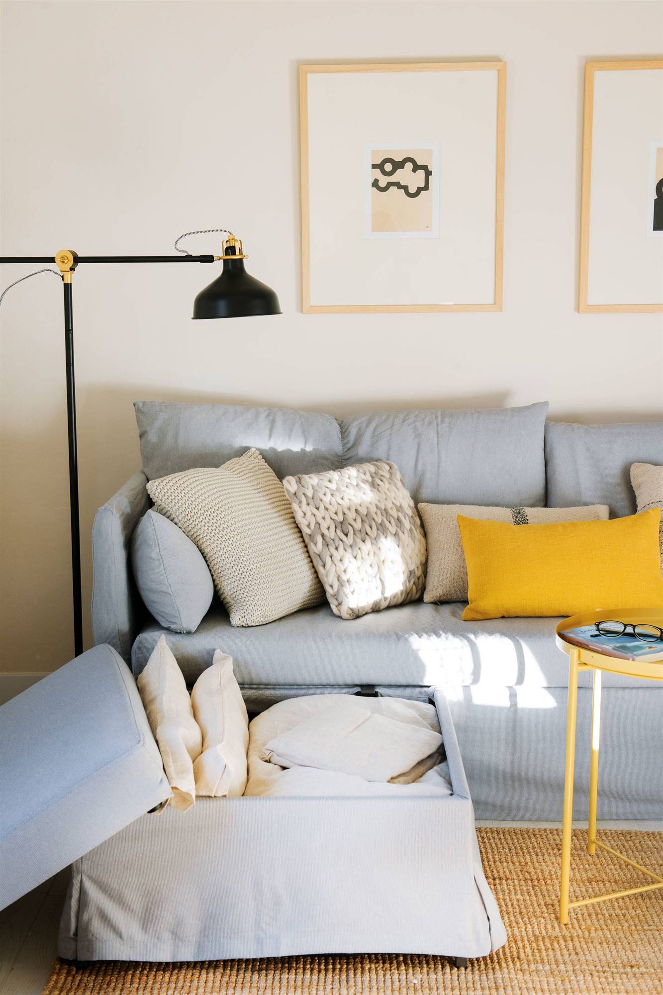 Sofá cama esquinero azul con alfombra de fibra y mesa de centro amarilla