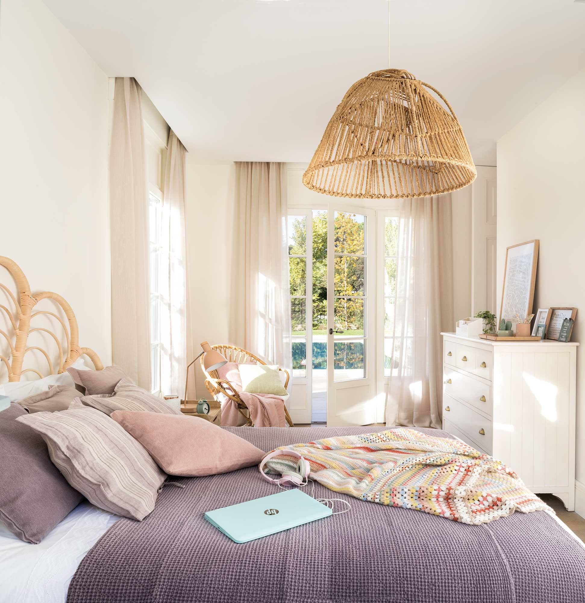 Dormitorio de primavera con cómoda blanca y cabecero y lámpara de techo de fibra.