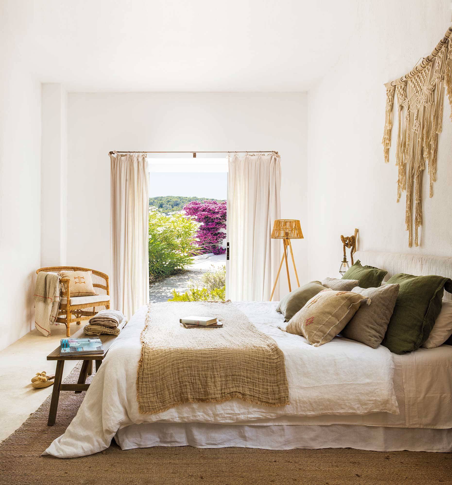 Dormitorio de primavera en tonos beiges y verdes y decoración artesanal en pared.