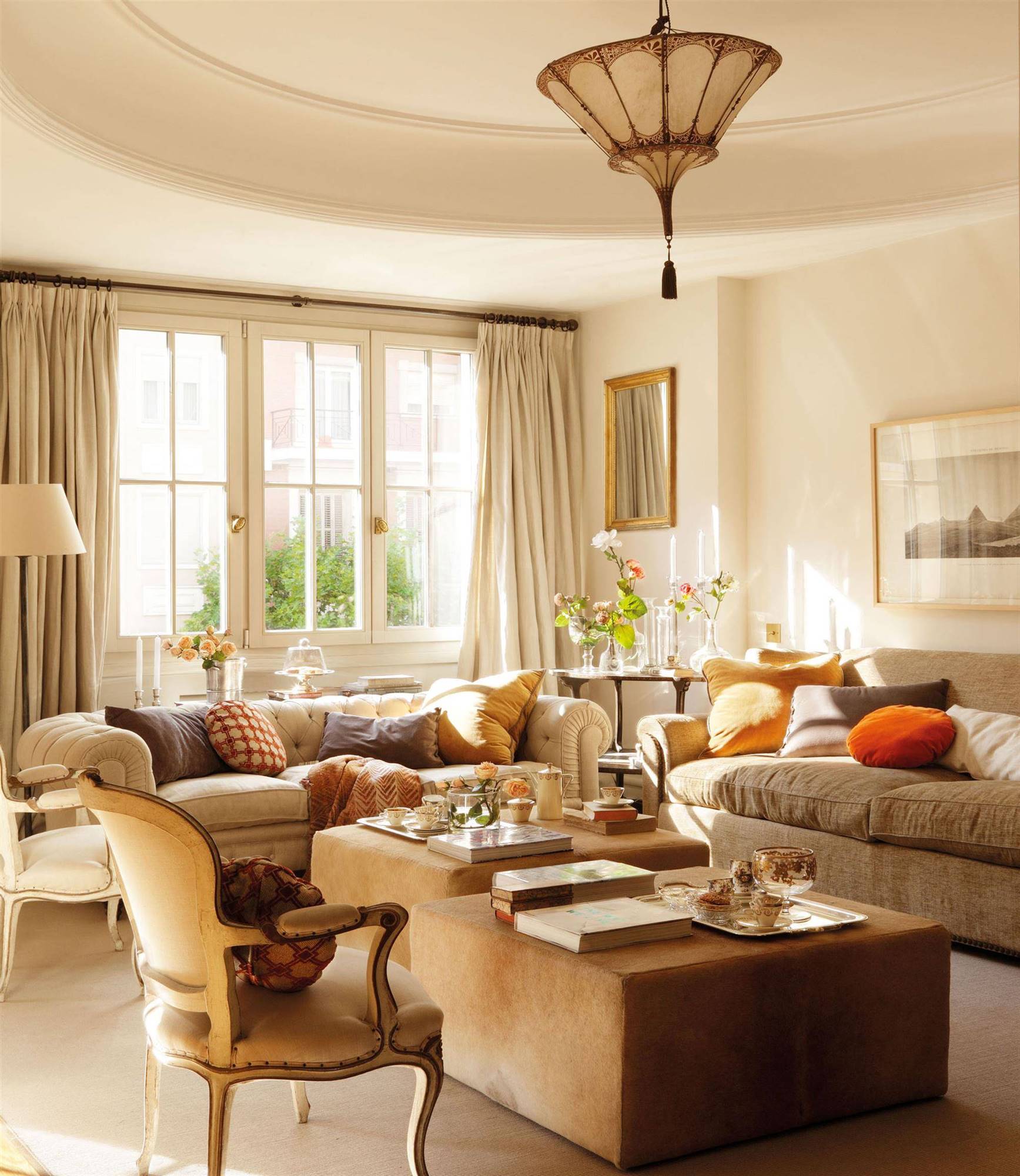 salón clásico con sofás en beige y gris, butacas con brazos y lámpara de techo