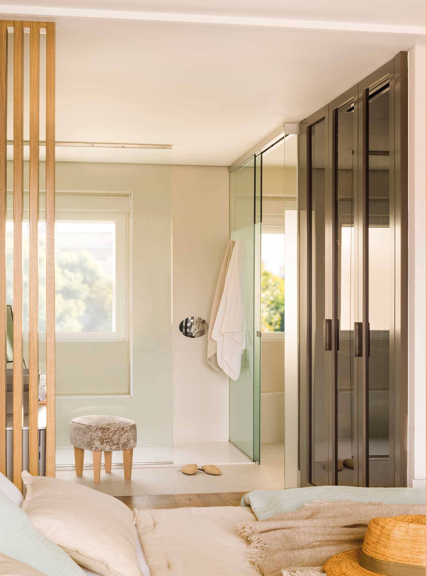 Baño reformado con ducha acristalada y sanitarios separados en una cabina. 