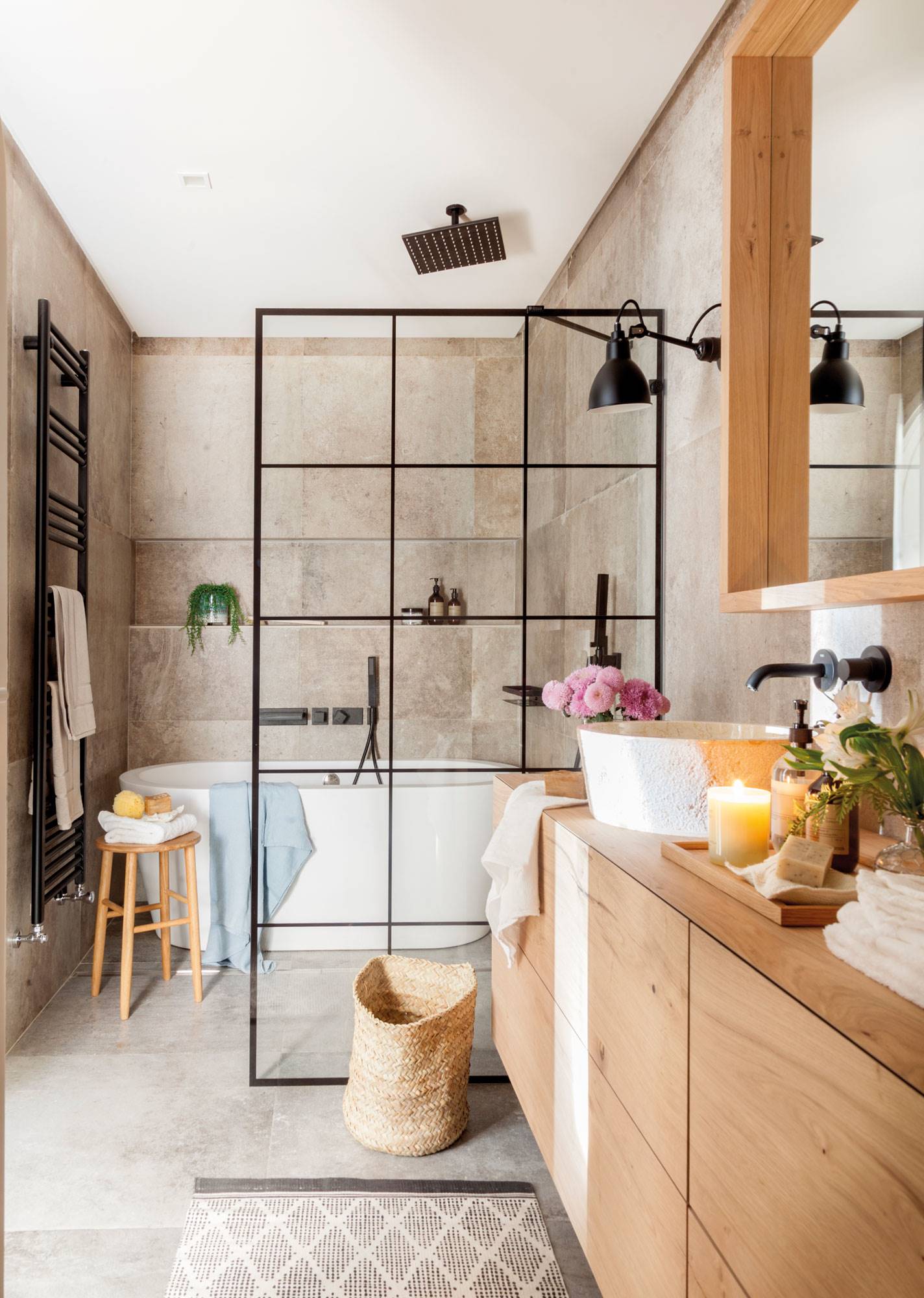 Baño reformado con bañera extenta, pared acristalada de cuarterones como mampara y mueble bajolavabo de madera. 