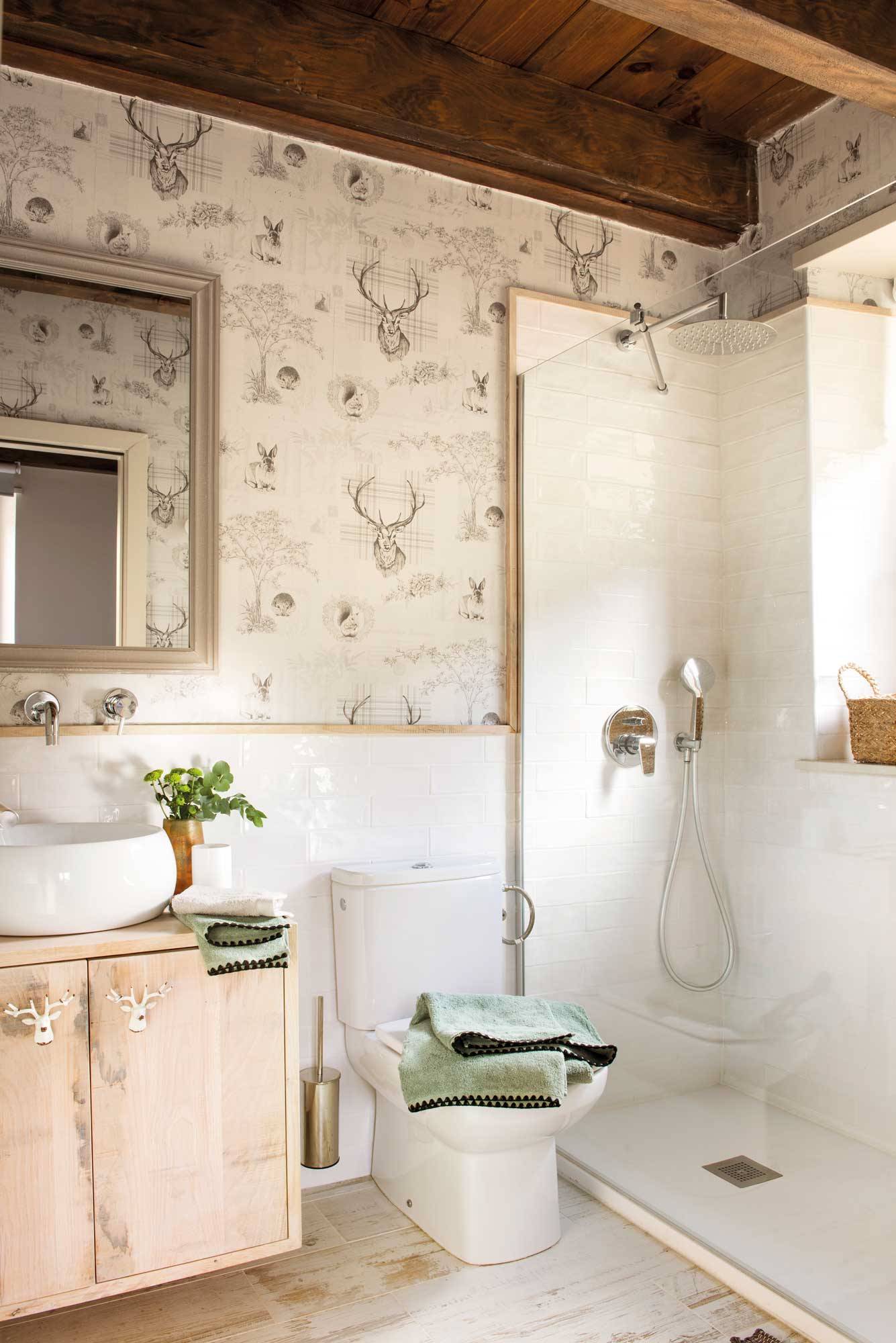 Baño reformado con estilo rústico con mueble suspendido, ducha con mampara, arrimadero y papel pintado. 