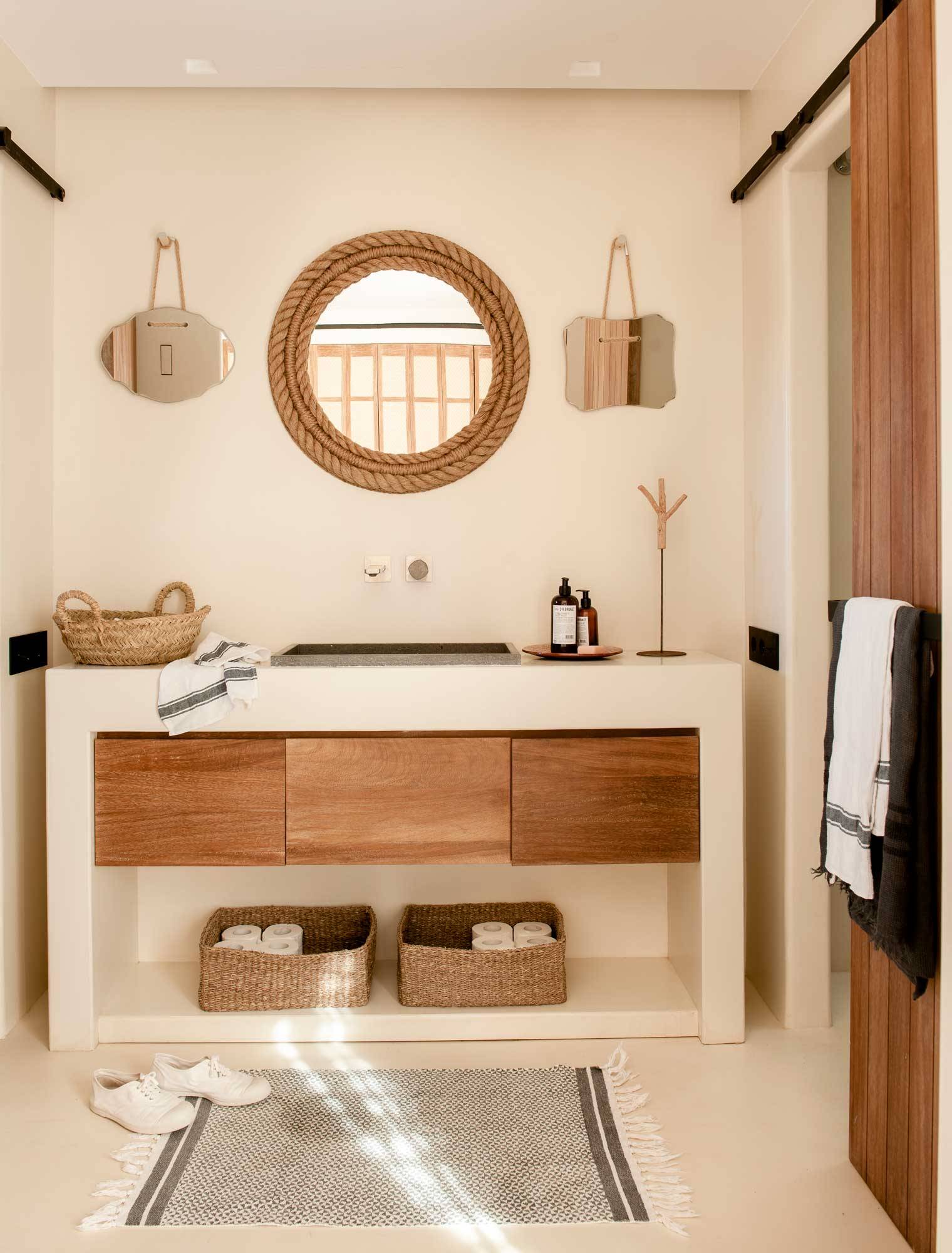 Baño reformado con pavimento de microcemento y mueble de madera. 
