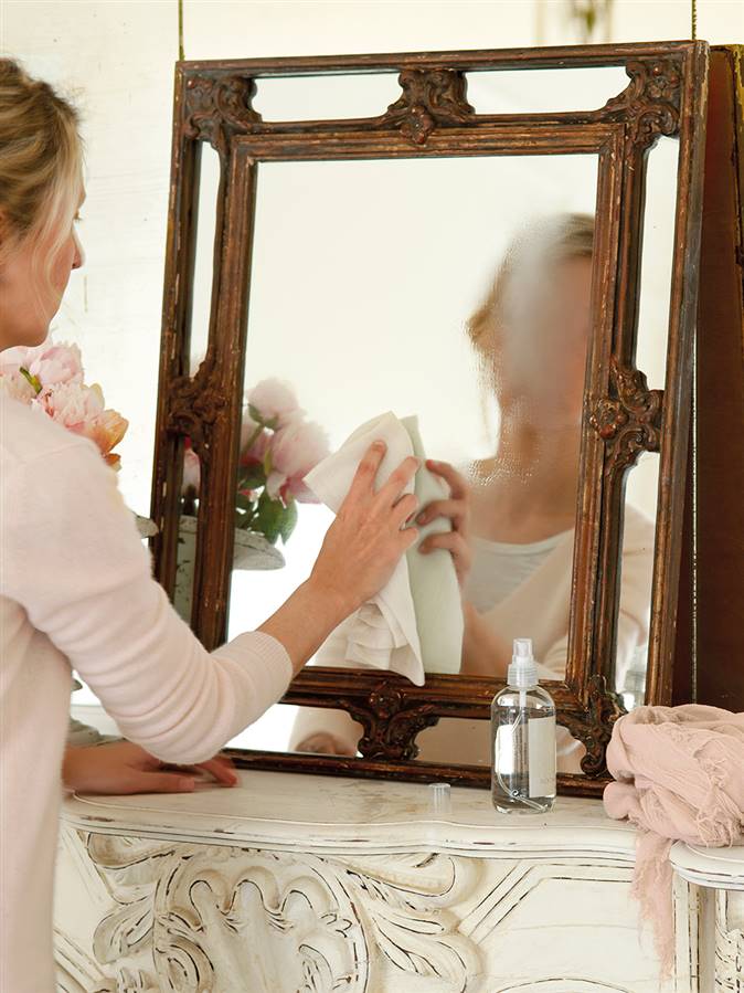 Mujer limpiando espejo