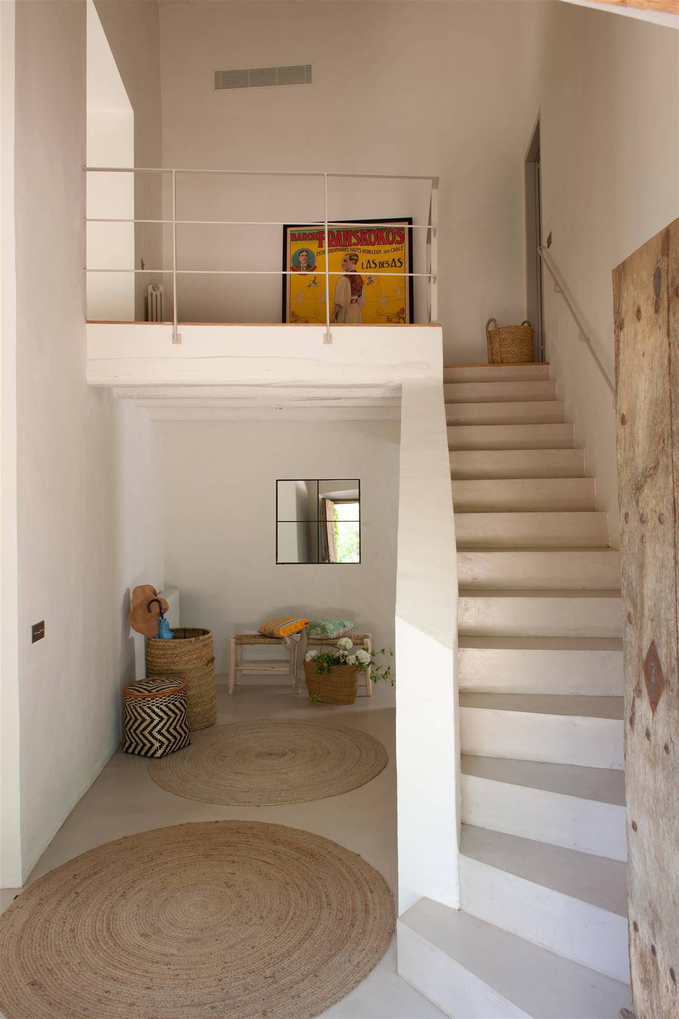 Zona de escaleras y pasillo con alfombras de fibras redondas. 