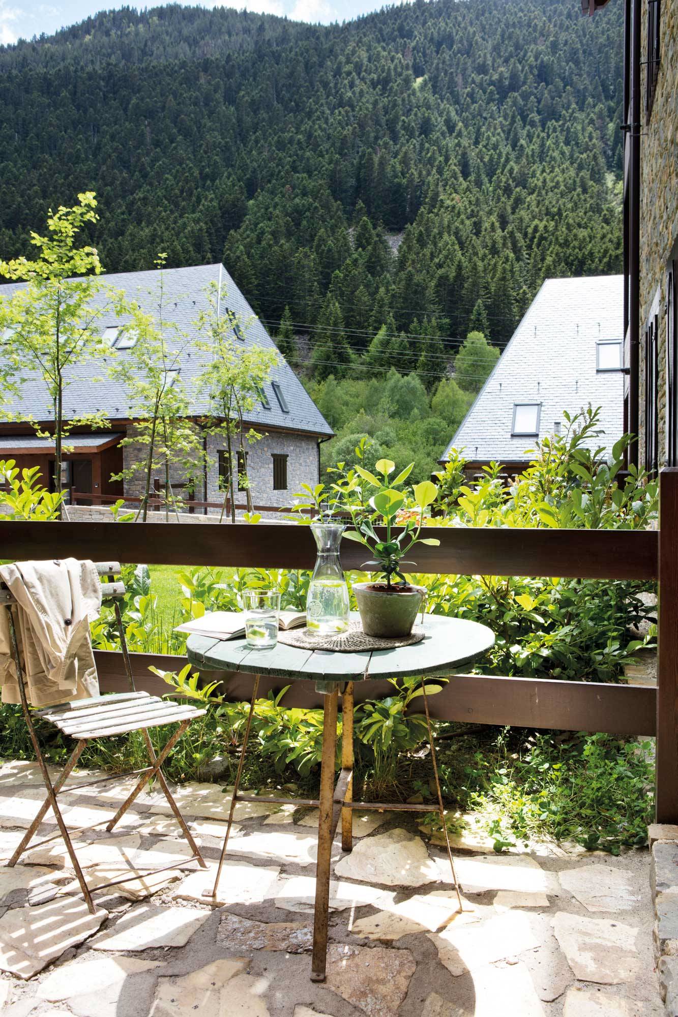 Comedor exterior pequeño en un balcón con vistas a la montaña.
