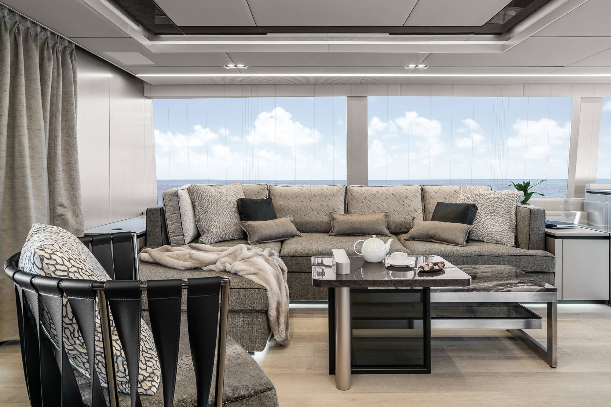 Salón con sofá y butaca en color gris en el catamarán de Rafa Nadal
