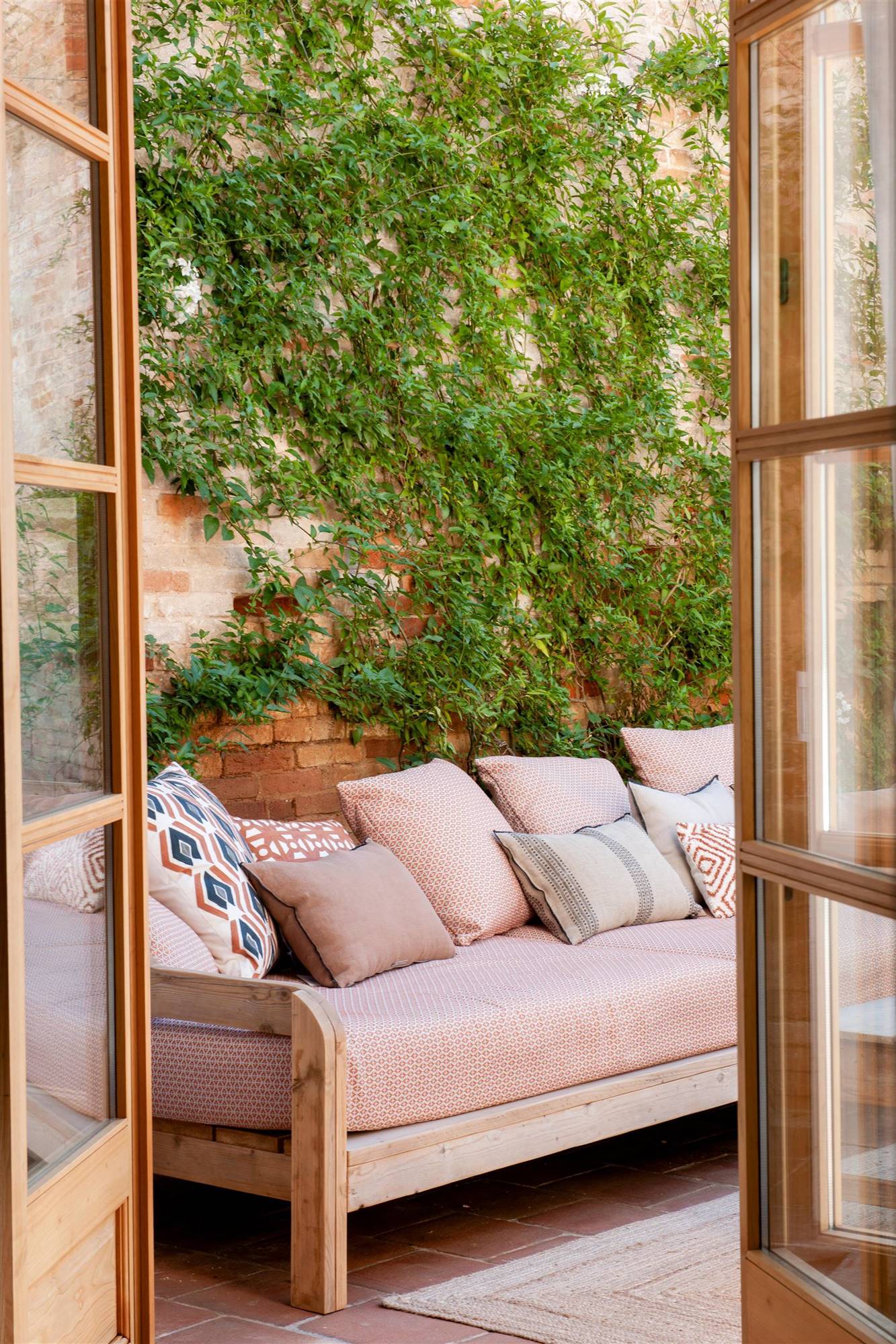 terraza-con-sofa-de-madera-con-asiento-y-cojines-estampados-00510330 O