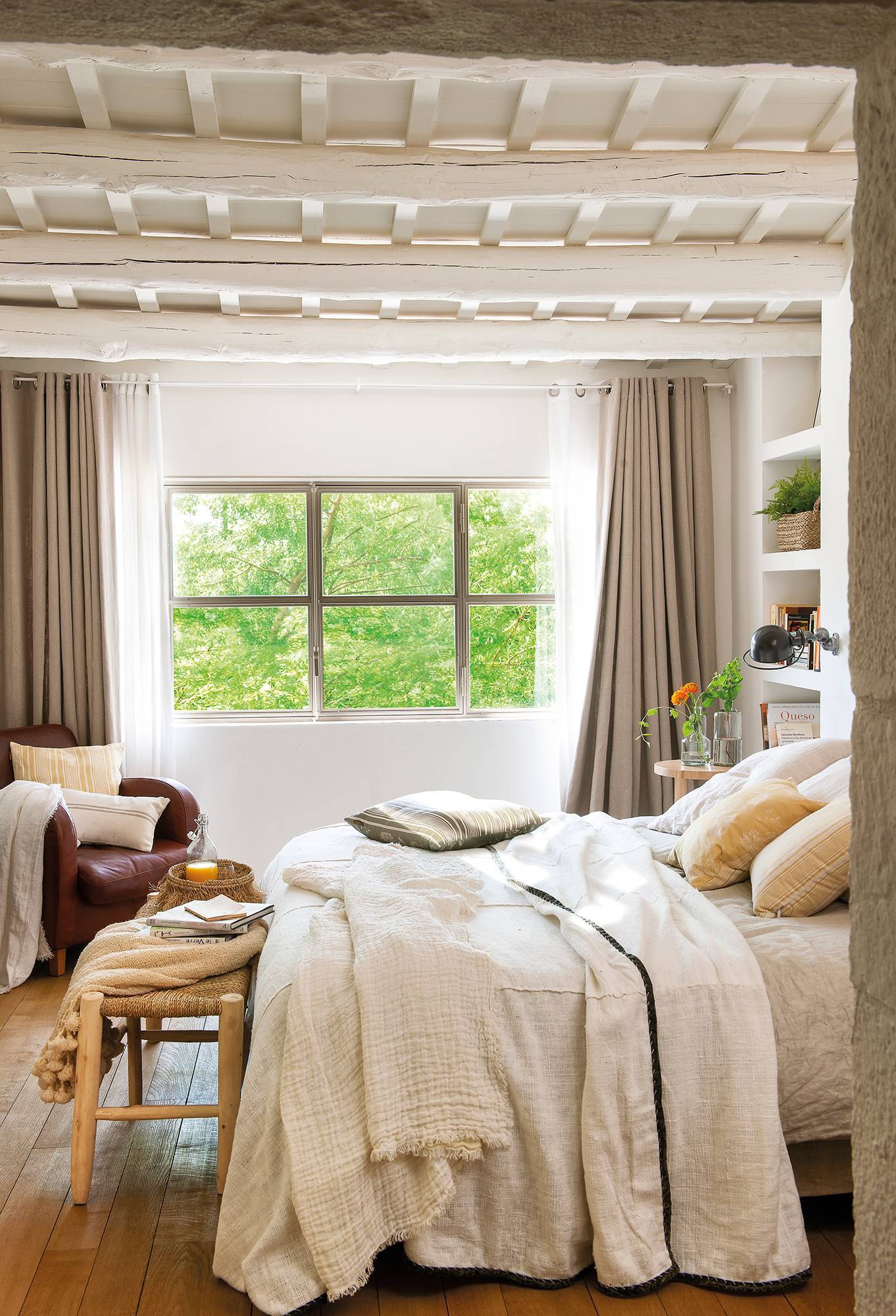 Dormitorio en blanco con vigas de madera pintadas