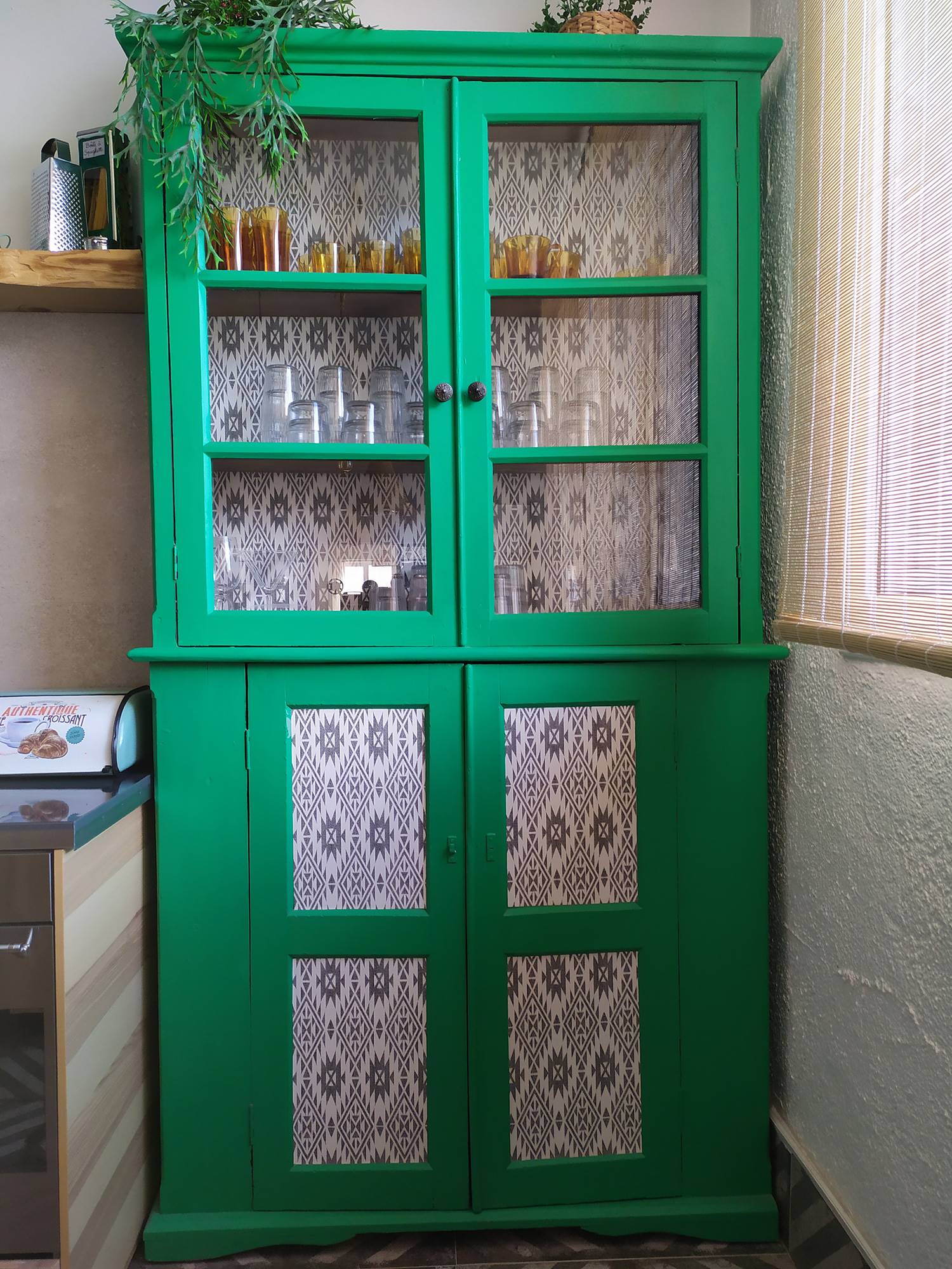Alacena vintage de color verde decorada con papel pintado con motivos gráficos