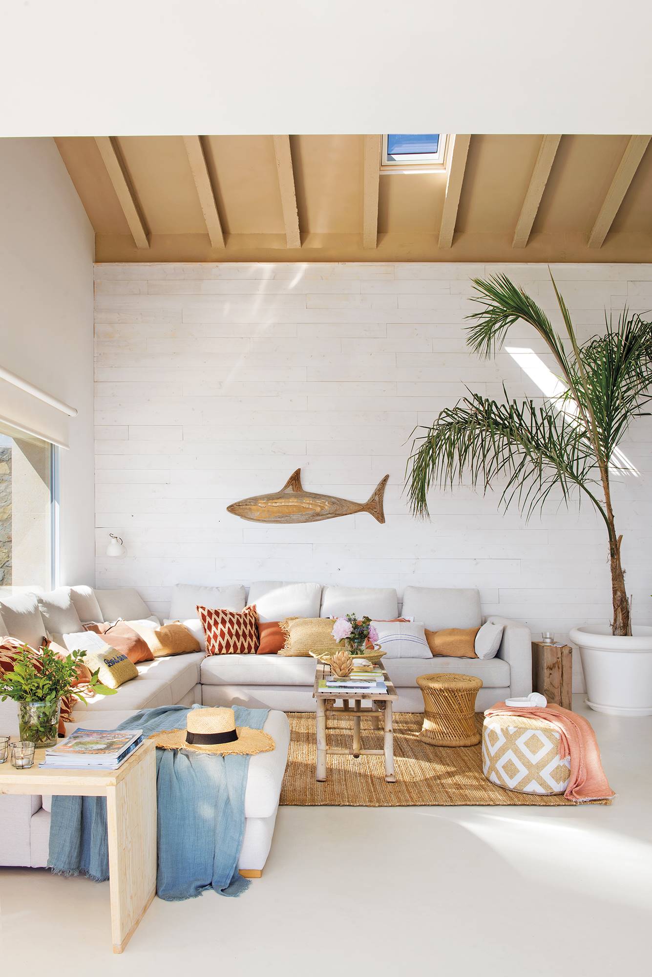 salón de verano con paredes blancas y gran sofá rinconero