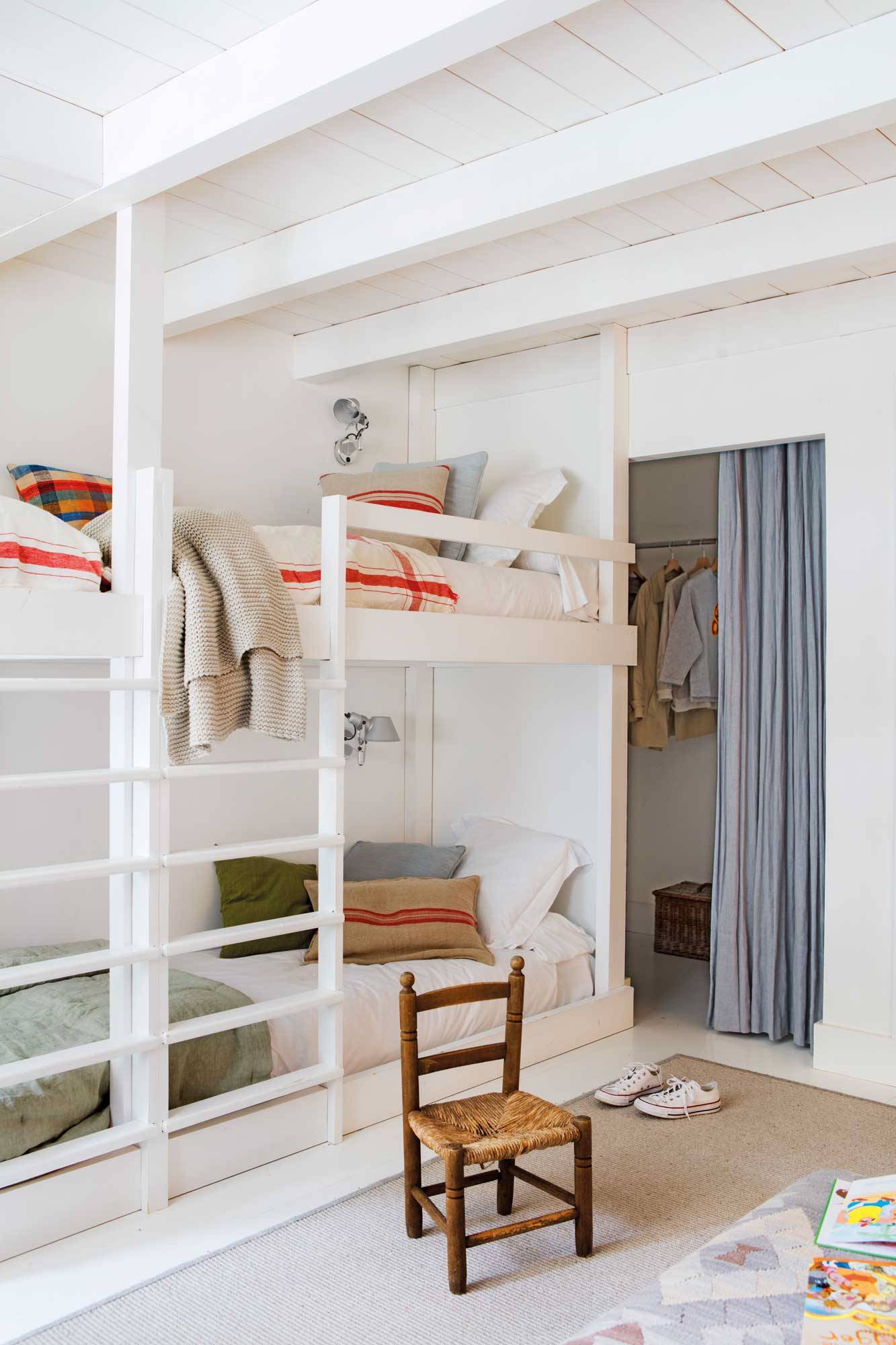 Dormitorio juvenil con literas blancas.