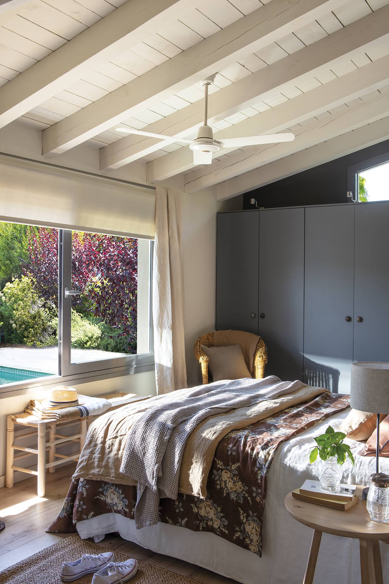 Dormitorio con armarios gris marengo y gran ventanal con vistas a la piscina