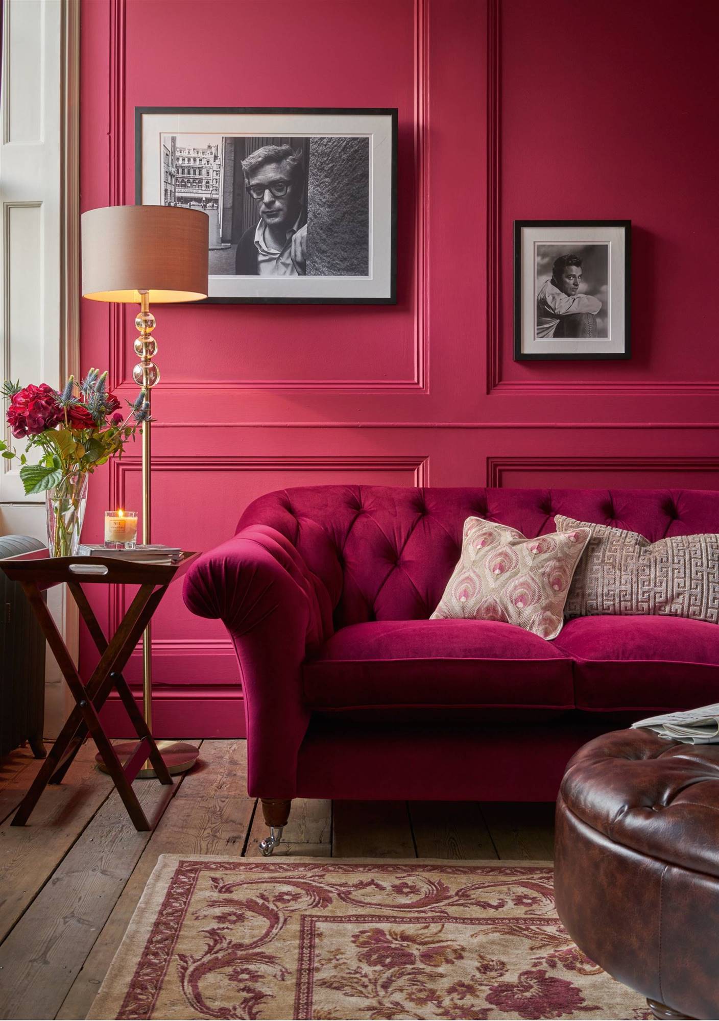 Salón de estilo clásico con pared en color magenta a juego con el sofá
