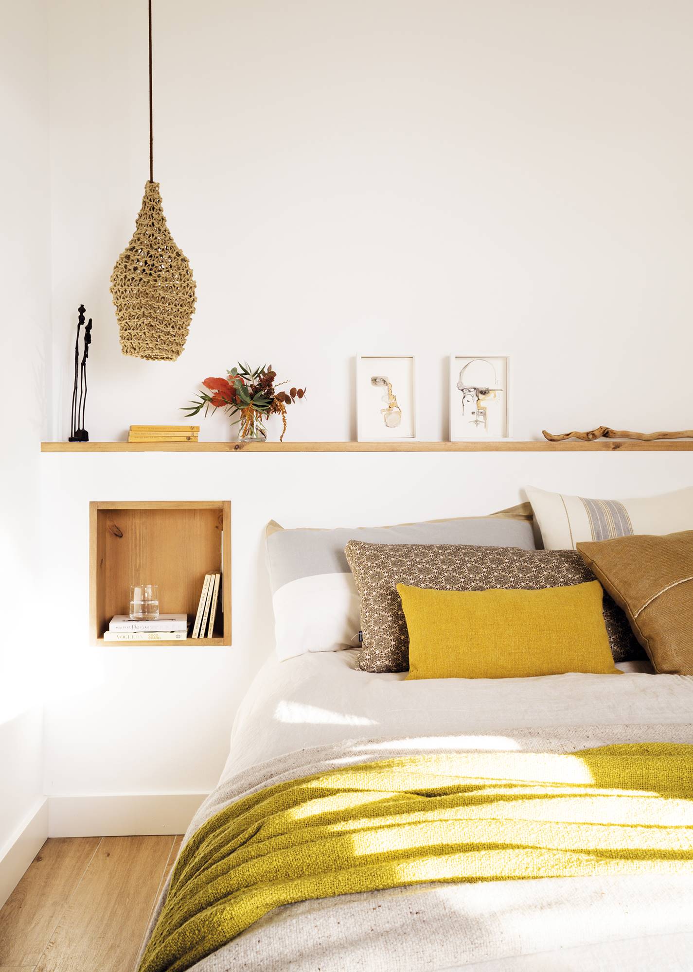 Dormitorio con cabecero de obra blanco con hornacina de madera a modo de mesilla.