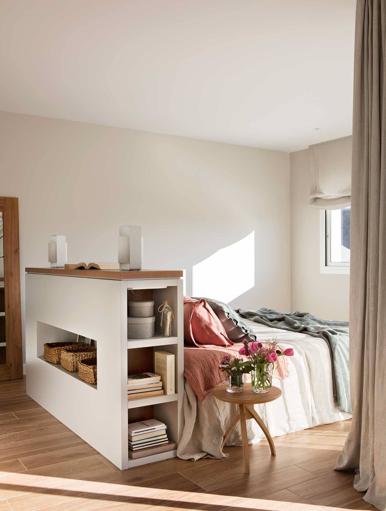 Dormitorio con cama en medio y cabecero con armarios, librería y hornacina para guardar00480630 O