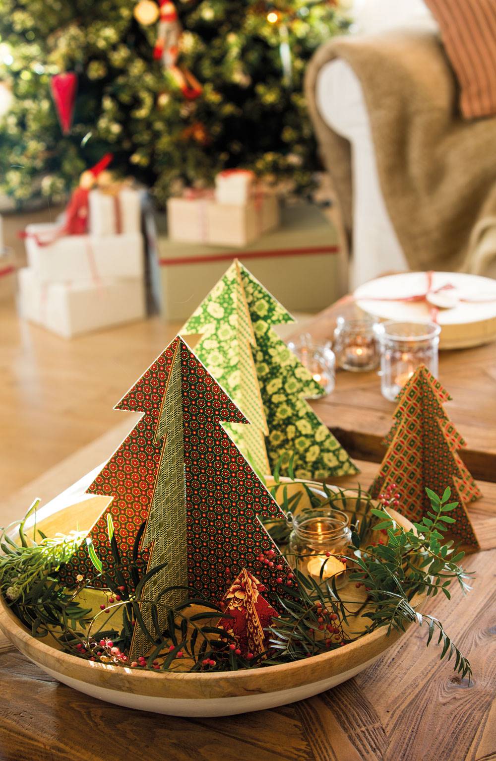 Adornos navideños en forma de árbol en mesa de centro. 