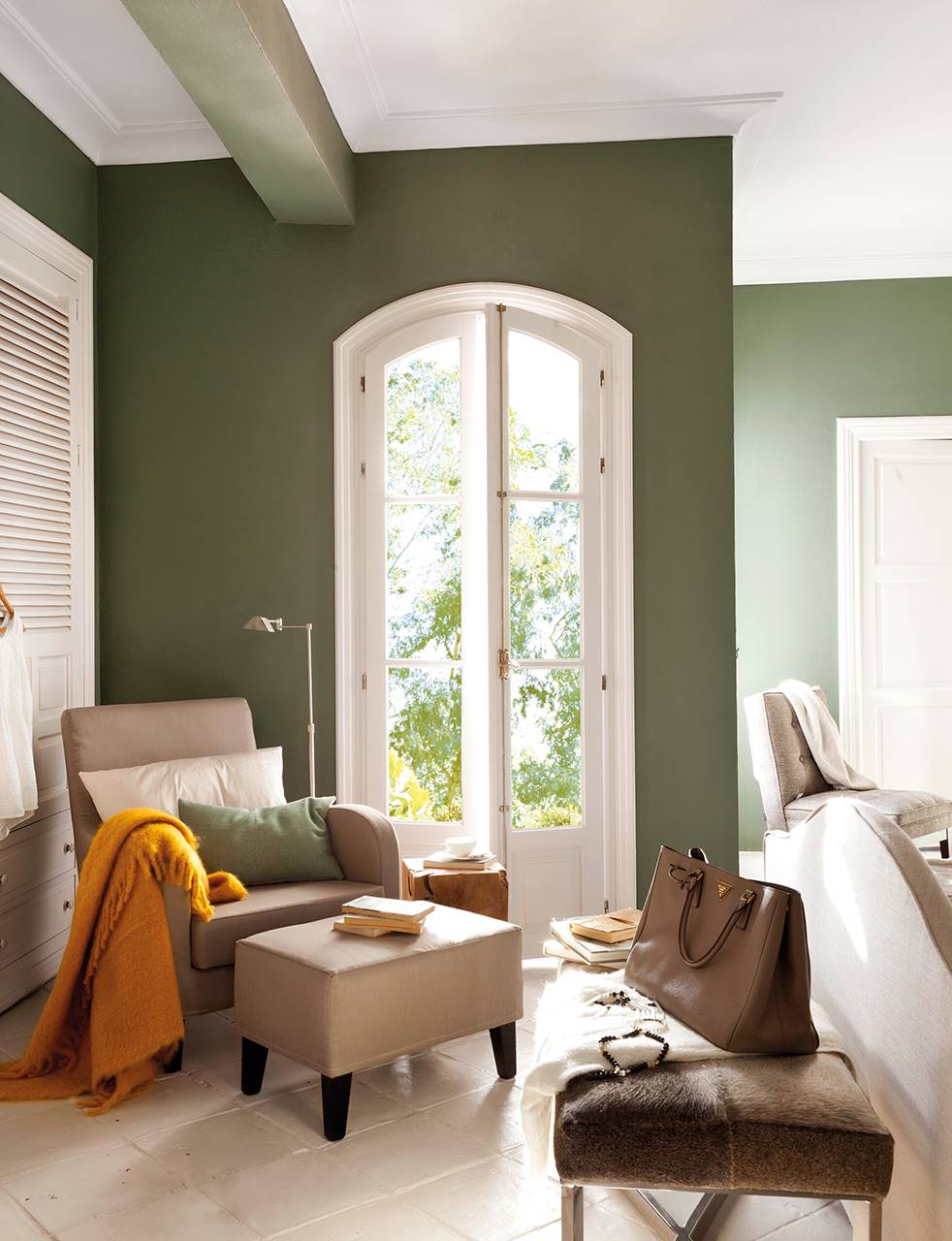 Dormitorio con zona de lectura y paredes en verde oliva
