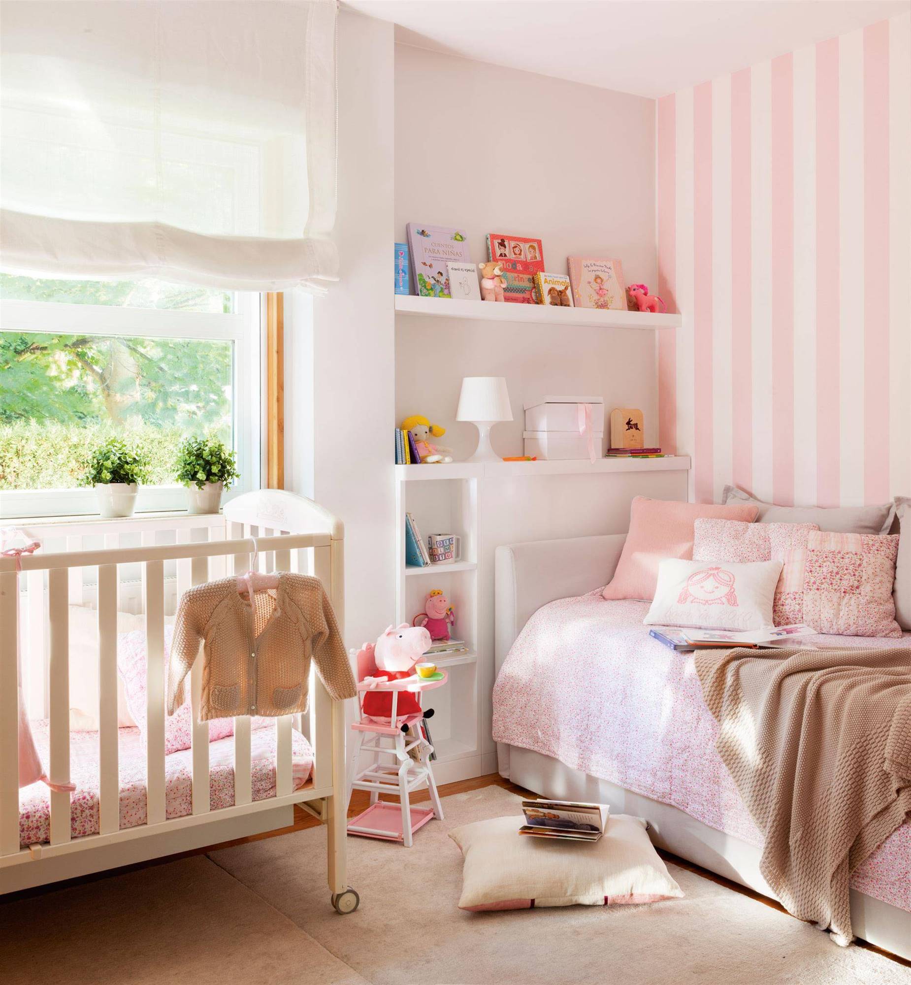 Habitación de bebé en tonos blancos y rosas.