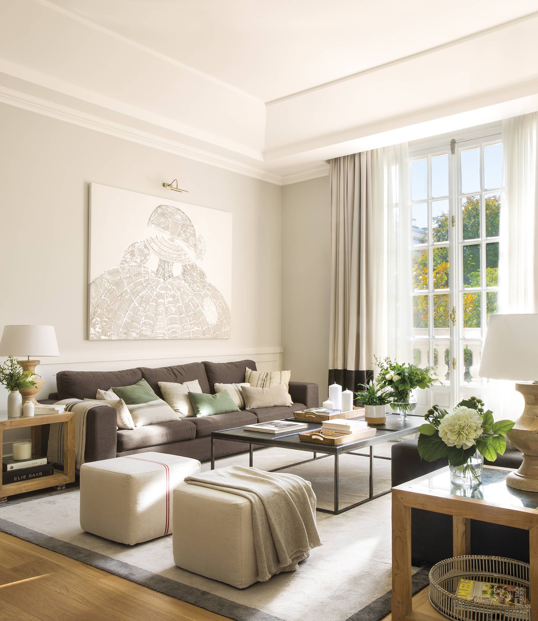 Salón señorial con dos sofás grises enfrentados y gran ventanal acristalado con cuarterones